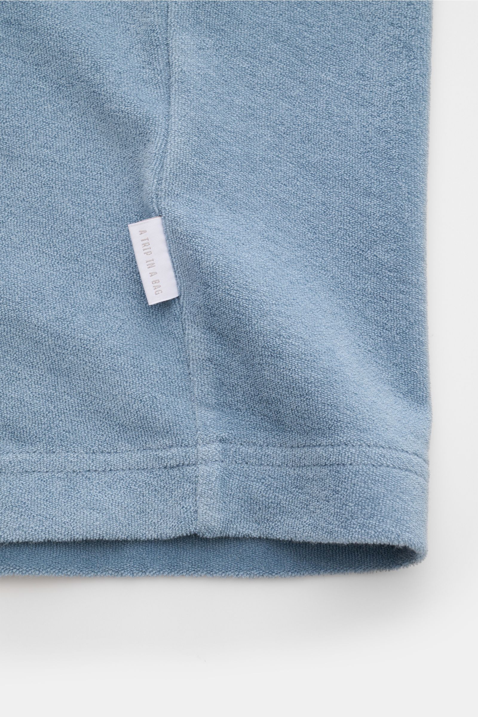 Close-up of the hem and side seam of the 04651/ A trip in a bag Terry T-shirt 'Terry Tee' smoky blue, showing soft pure cotton terrycloth fabric and small woven label, photographed from a flat lay perspective.

The clean T-shirt 'Terry Tee' by 04651/ A