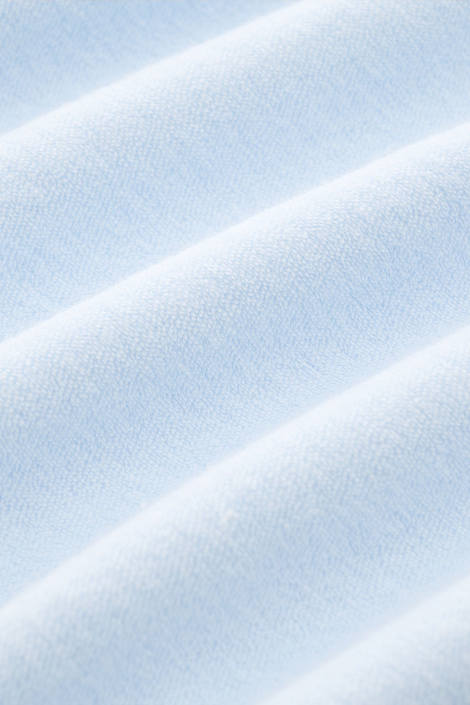 Close-up front view of pastel blue terrycloth fabric showing soft texture of 04651/ A trip in a bag Terry T-shirt 'Terry Tee' made of pure cotton. 

The clean T-shirt 'Terry Tee' by 04651/ A TRIP IN A BAG is made of soft terry in pure cotton fabric and