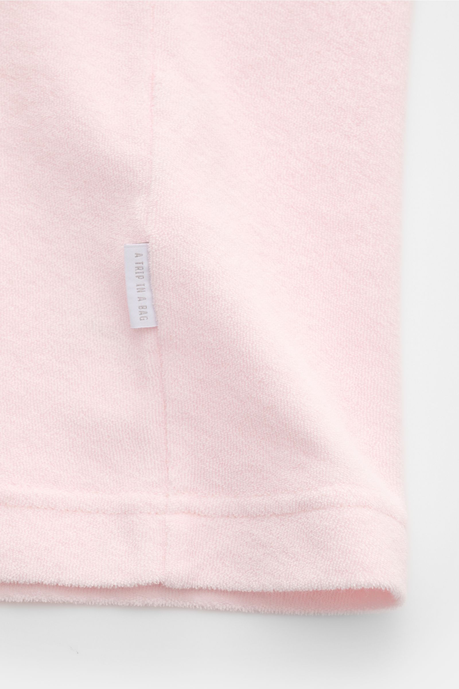 Close-up front view of the 04651/ A trip in a bag Terry T-shirt 'Terry Tee' rose showing soft terrycloth fabric and small woven label in side seam. The clean T-shirt 'Terry Tee' by 04651/ A TRIP IN A BAG is made of soft terry in pure cotton fabric and is 