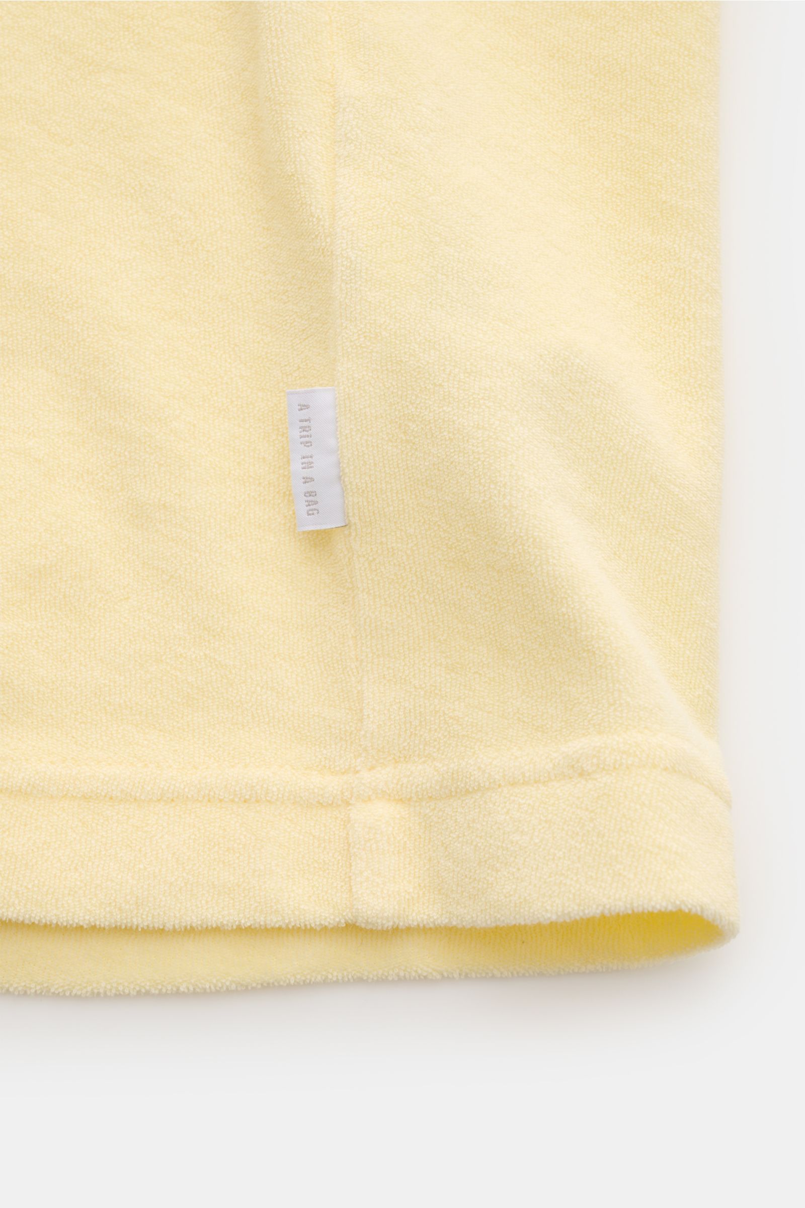 04651/ A trip in a bag Frottee T-Shirt 'Terry Tee' pastellgelb in Nahaufnahme von unten mit weichem Griff, Rundhalsausschnitt und kleinem Weblabel.