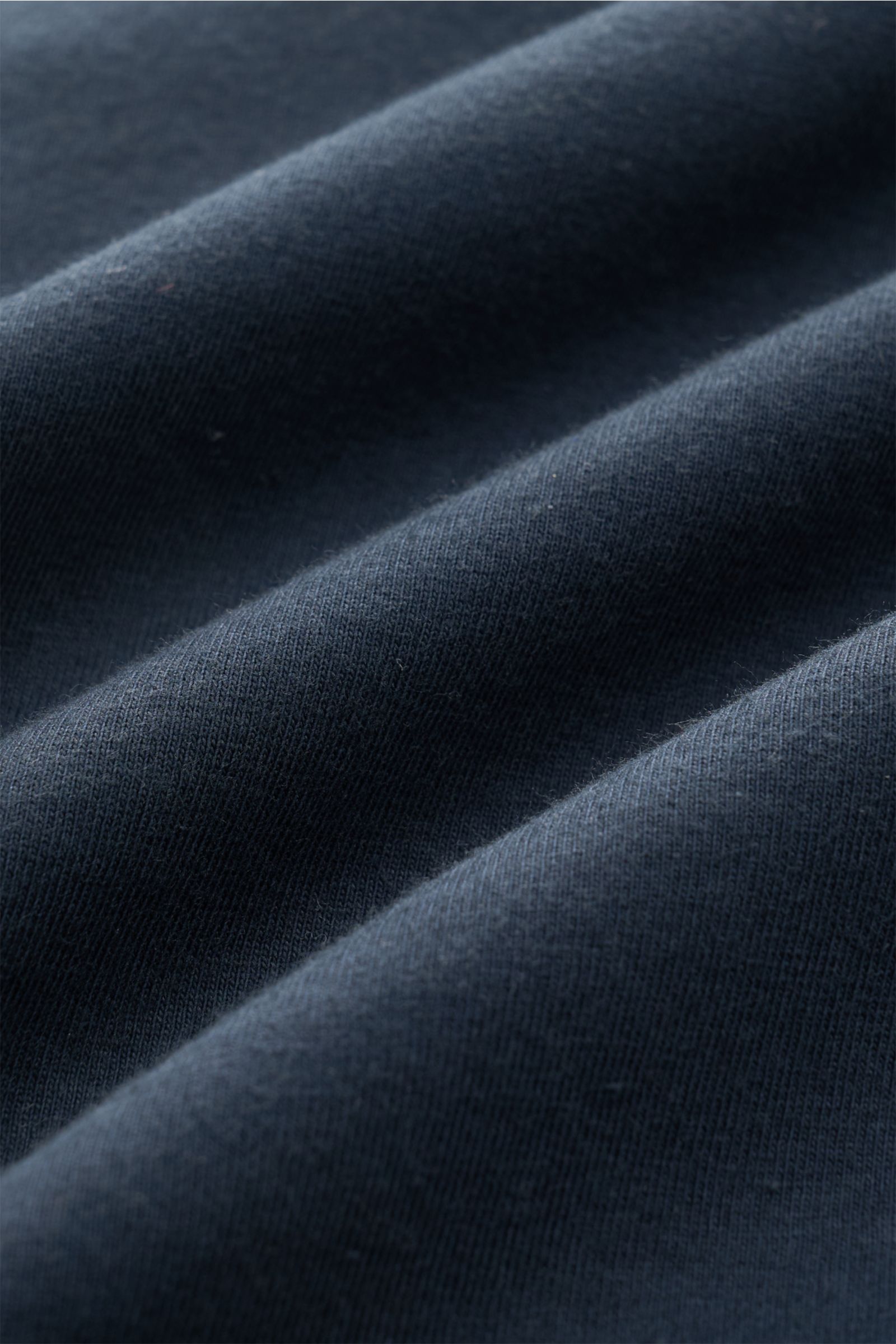 Makroaufnahme des Stoffes vom 04651/ A trip in a bag Rundhals-T-Shirt navy, Jersey aus reiner Baumwolle, weicher Griff, Regular Fit, Rundhalsausschnitt, kleines Weblabel, kurze Saumschlitze.