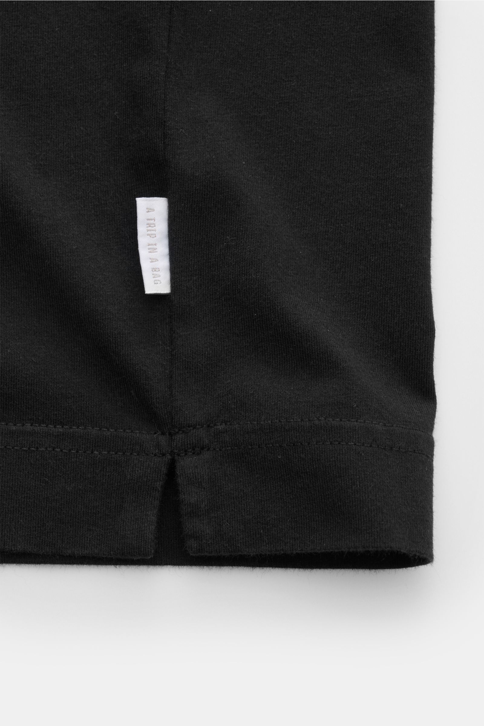 Schwarzes Detailbild vom Saum des 04651/ A trip in a bag Rundhals-T-Shirts schwarz, Jersey aus reiner Baumwolle, weicher Griff, Regular Fit, Rundhalsausschnitt, kleines Weblabel, kurze Saumschlitze.