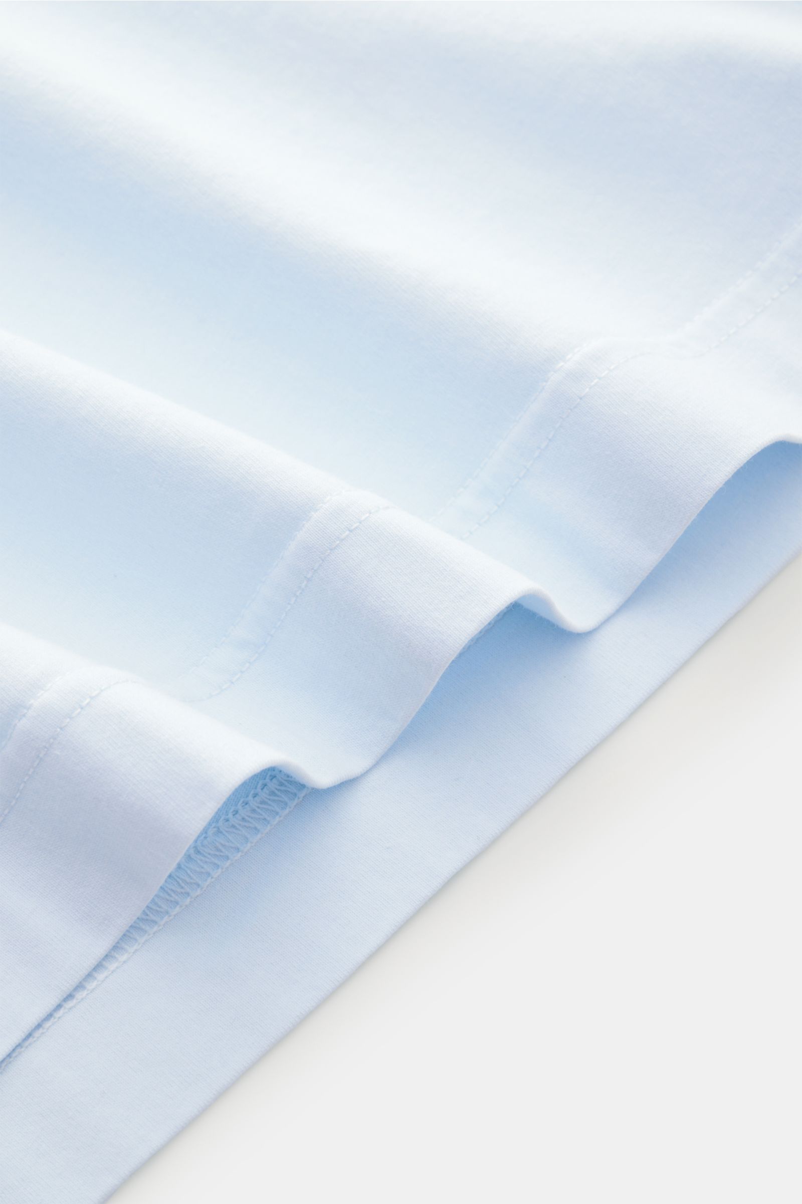 04651/ A trip in a bag Rundhals-T-Shirt pastellblau, Detailansicht Saum, Jersey aus reiner Baumwolle, weicher Griff, Regular Fit, Rundhalsausschnitt, kleines Weblabel.