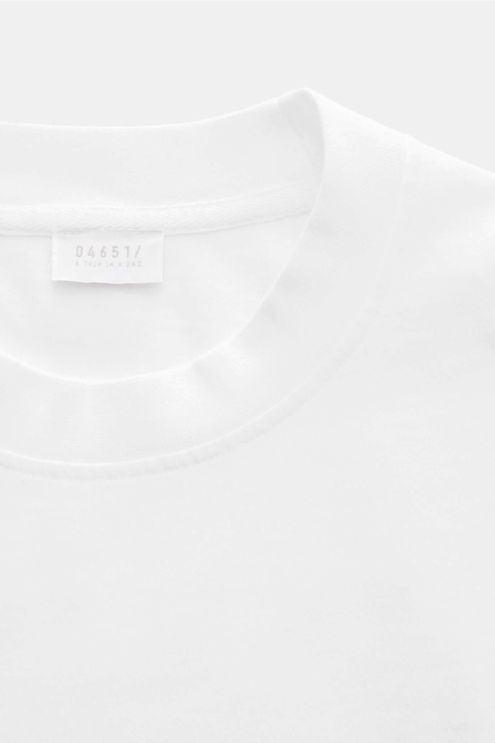 04651/ A trip in a bag T-Shirt 'Nunu' weiß, Nahaufnahme von Rundhalsausschnitt und Label, reine Baumwolle, weicher Griff, Regular Fit, rückwärtiger Print.
