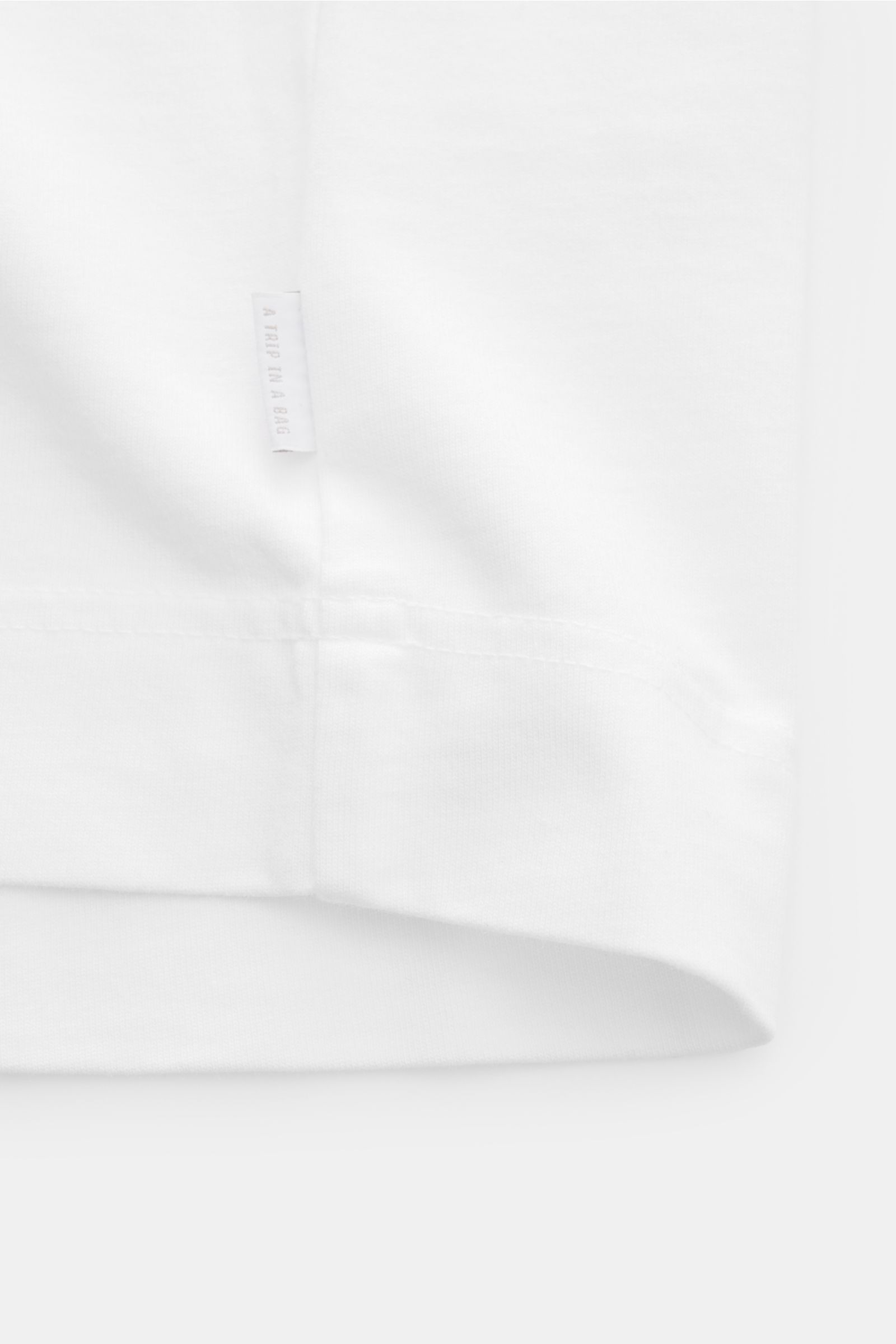 Weißer Stoffdetail-Ausschnitt des 04651/ A trip in a bag T-Shirts 'Nunu' weiß, Rückseite mit Label, Baumwolle, weicher Griff, Regular Fit.