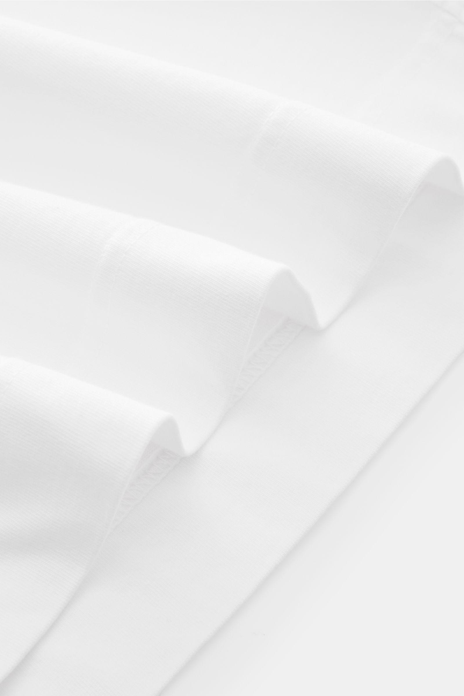 04651/ A trip in a bag T-Shirt 'Nunu' weiß, Detailaufnahme Saum und Ärmel, Basic T-Shirt aus reiner Baumwolle mit weichem Griff, Regular Fit, Rundhalsausschnitt, rückwärtiger Print.