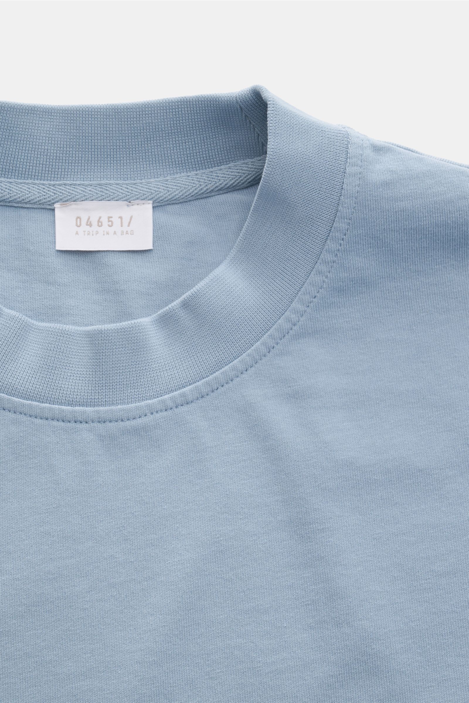 Close-up front view of 04651/ A trip in a bag T-shirt 'Nunu' smoky blue, showing crew neck and soft pure cotton fabric.

Description: 
A basic with a print accent: With its minimalist holiday print, this T-shirt by 04651/ A TRIP IN A BAG makes a modern