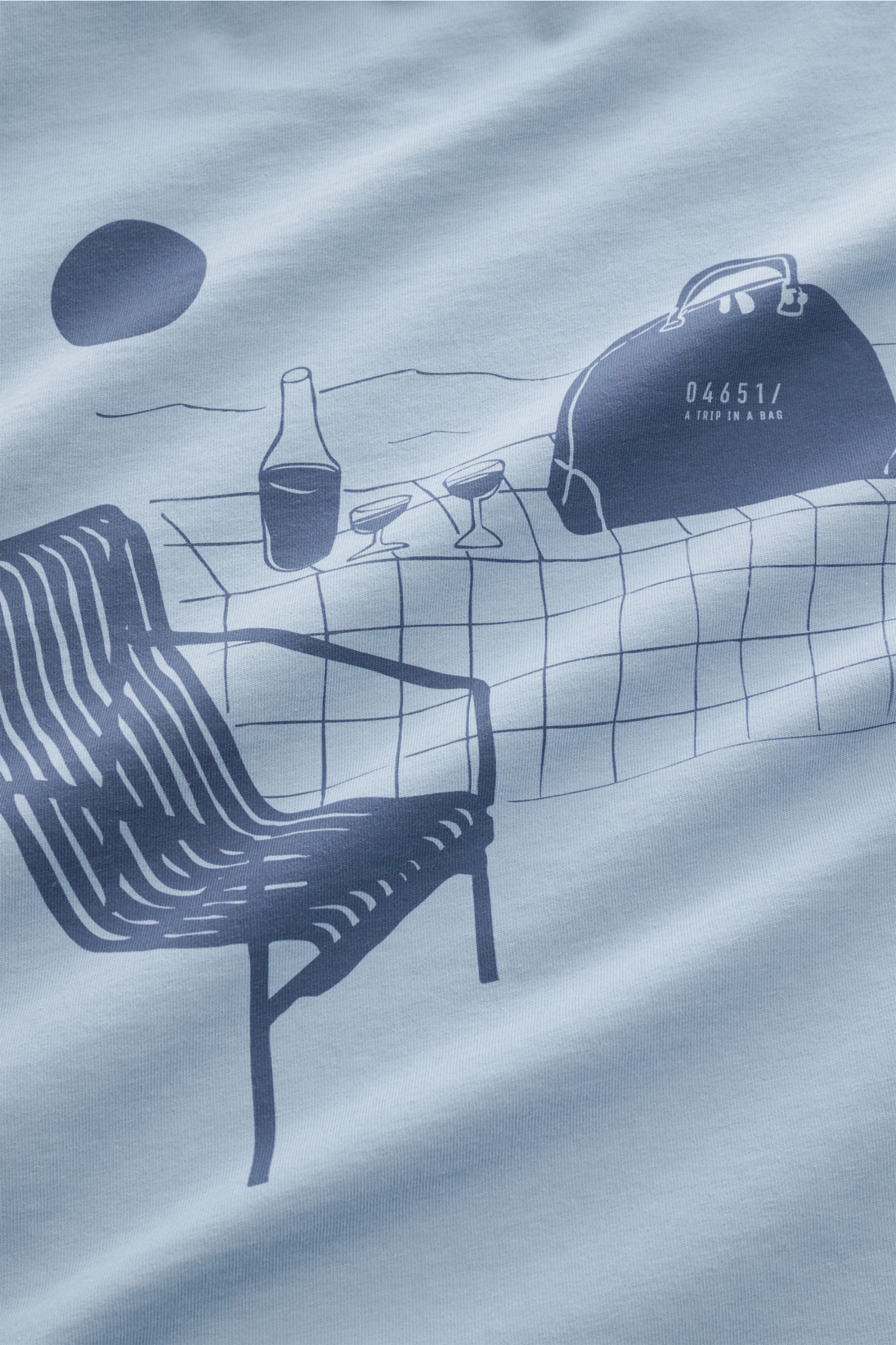 Close-up front view of 04651/ A trip in a bag T-shirt 'Nunu' smoky blue showing a minimalist print of a chair, bottle, glasses, and bag.

A basic with a print accent: With its minimalist holiday print, this T-shirt by 04651/ A TRIP IN A BAG makes a mod