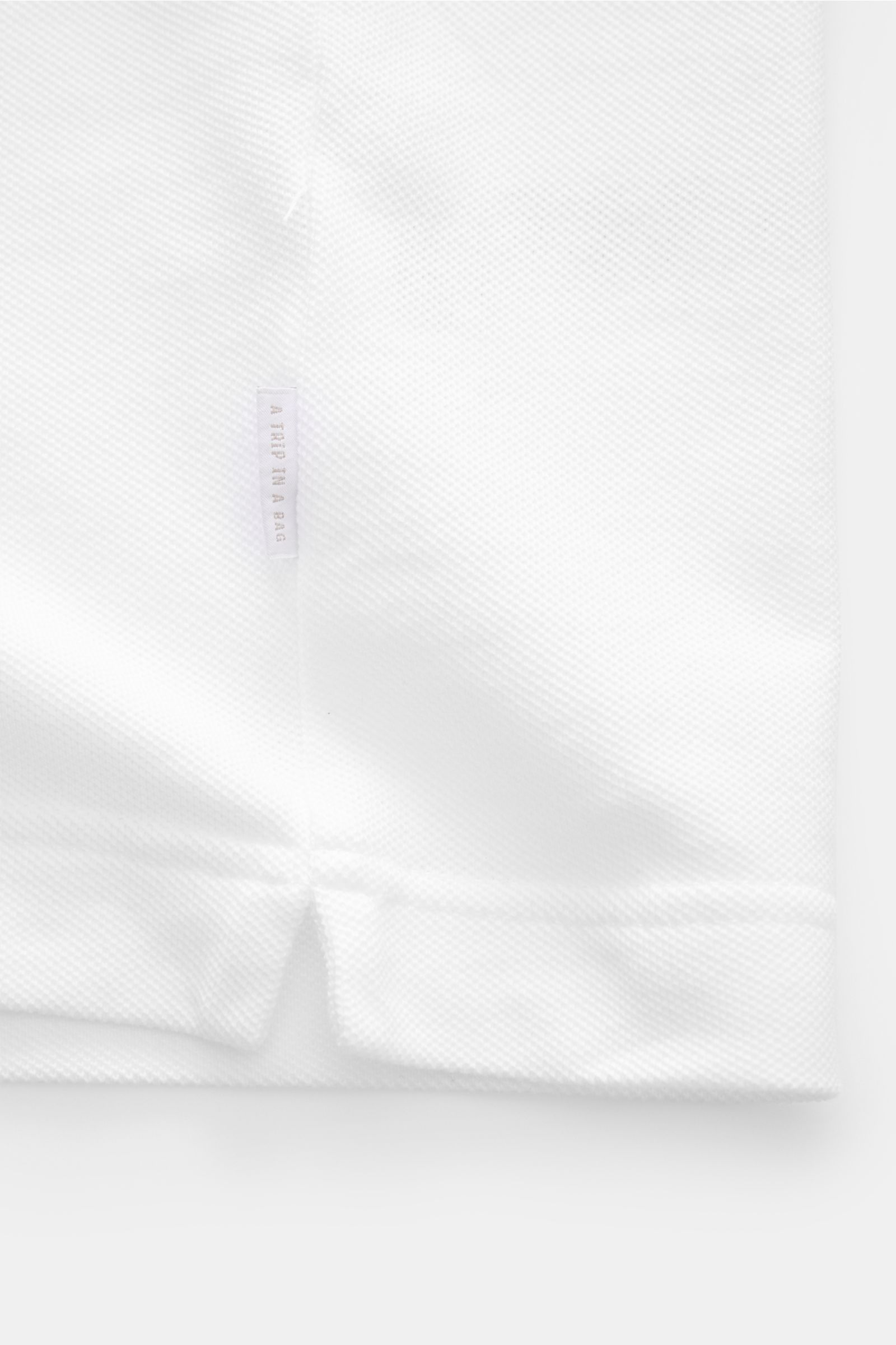 Close-up front view of the 04651/ A trip in a bag Piqué T-shirt white showing pure piqué cotton texture, ribbed bands, and woven side seam label.

Summer essential: This piqué T-shirt from 04651/ A TRIP IN A BAG is a versatile staple that's perfect for