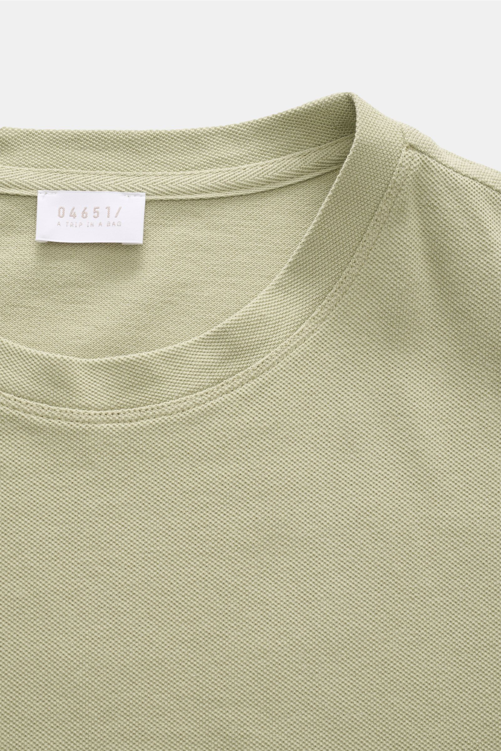 Close-up front view of the 04651/ A trip in a bag Piqué T-shirt sage, showing crew neck and woven label inside.

Summer essential: This piqué T-shirt from 04651/ A TRIP IN A BAG is a versatile staple that's perfect for warm days.

Pure piqu