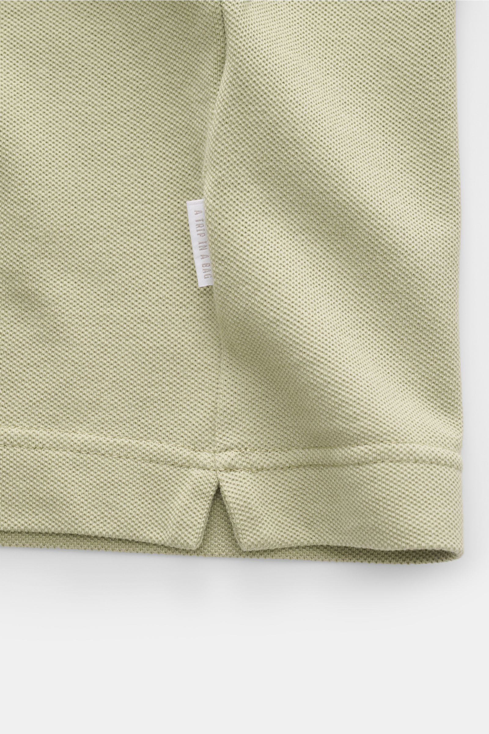 Close-up front view of the hem and side seam with woven label on the 04651/ A trip in a bag Piqué T-shirt sage in pure piqué cotton.

Summer essential: This piqué T-shirt from 04651/ A TRIP IN A BAG is a versatile staple that's perfect for warm days.