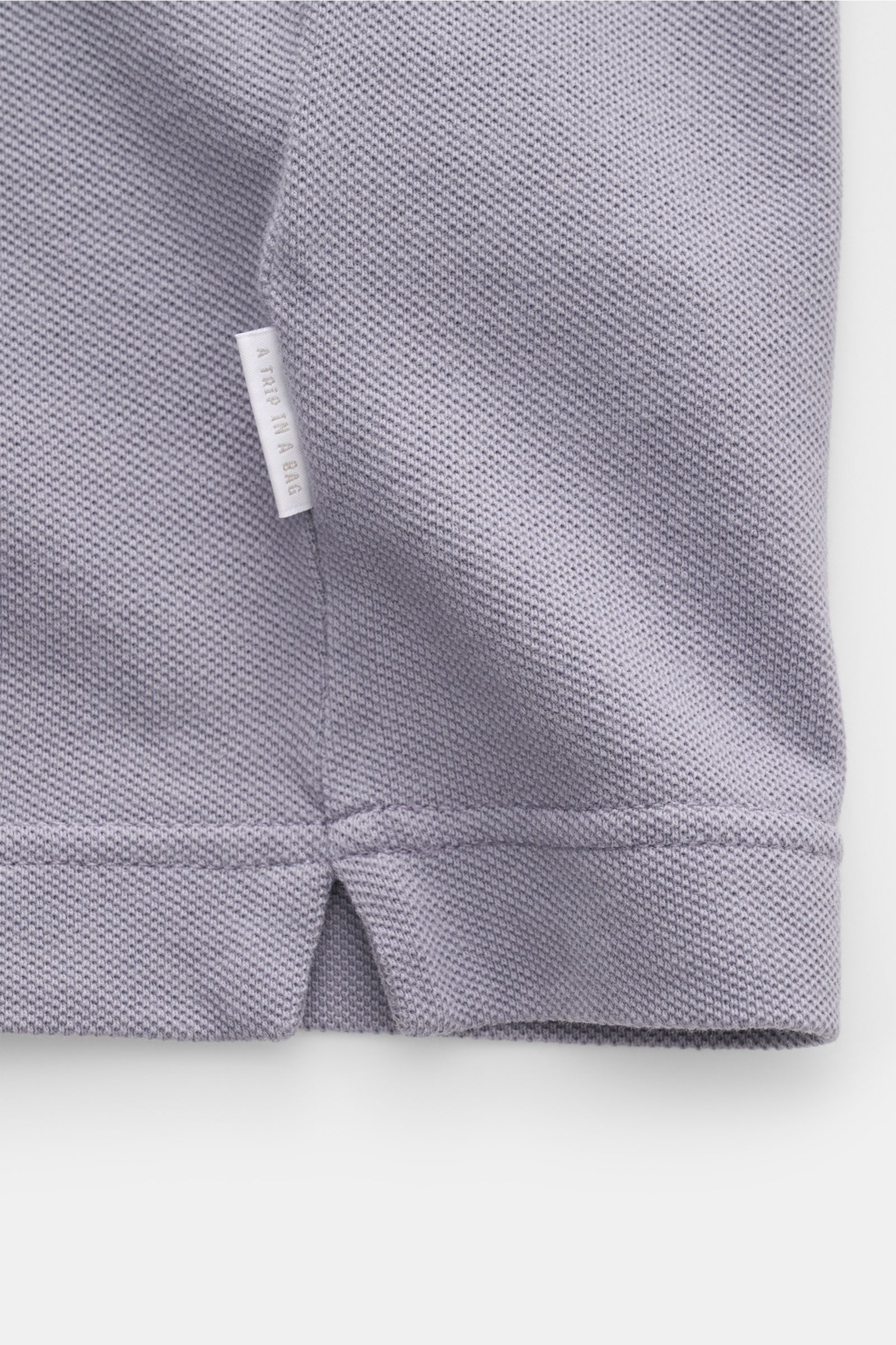 Close-up side seam of the 04651/ A trip in a bag Piqué T-shirt lavender showing woven label and textured piqué cotton fabric, photographed from the side.

Summer essential: This piqué T-shirt from 04651/ A TRIP IN A BAG is a versatile staple that's per