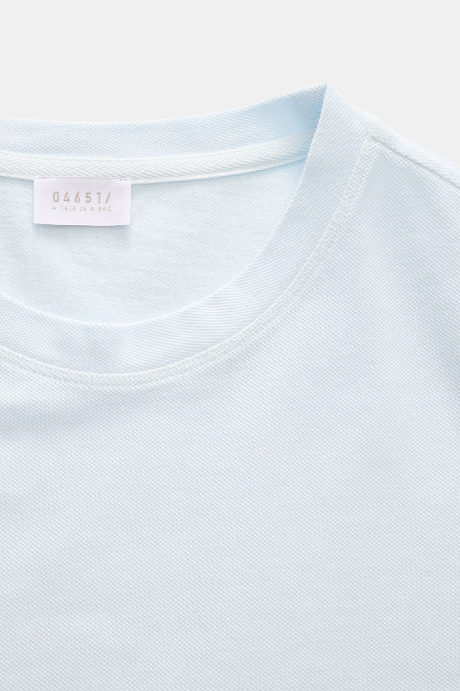 Close-up front view of the pastel blue 04651/ A trip in a bag Piqué T-shirt showing the crew neck and woven label inside.

Summer essential: This piqué T-shirt from 04651/ A TRIP IN A BAG is a versatile staple that's perfect for warm days.


