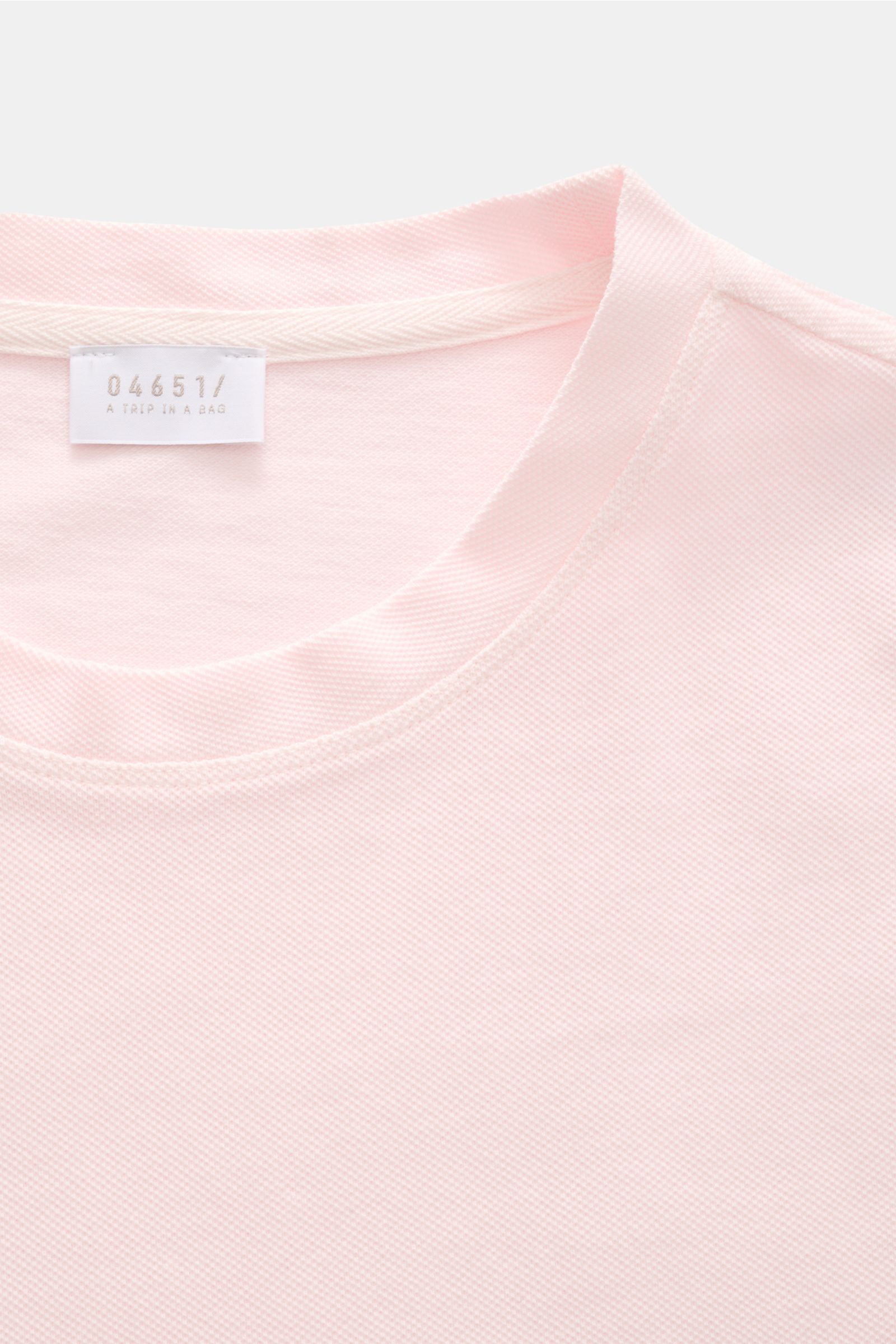 Close-up front view of 04651/ A trip in a bag Piqué T-shirt rose showing crew neck and label, summer essential slim fit.