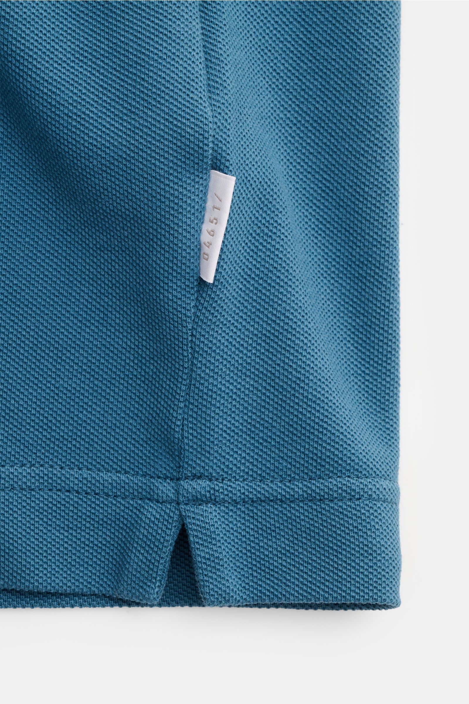 Close-up side view of the hem on the 04651/ A trip in a bag Piqué T-shirt teal, showing pure piqué cotton texture, slim fit, woven label, ribbed bands, and robust feel. 

Summer essential: This piqué T-shirt from 04651/ A TRIP IN A BAG is a versatile s