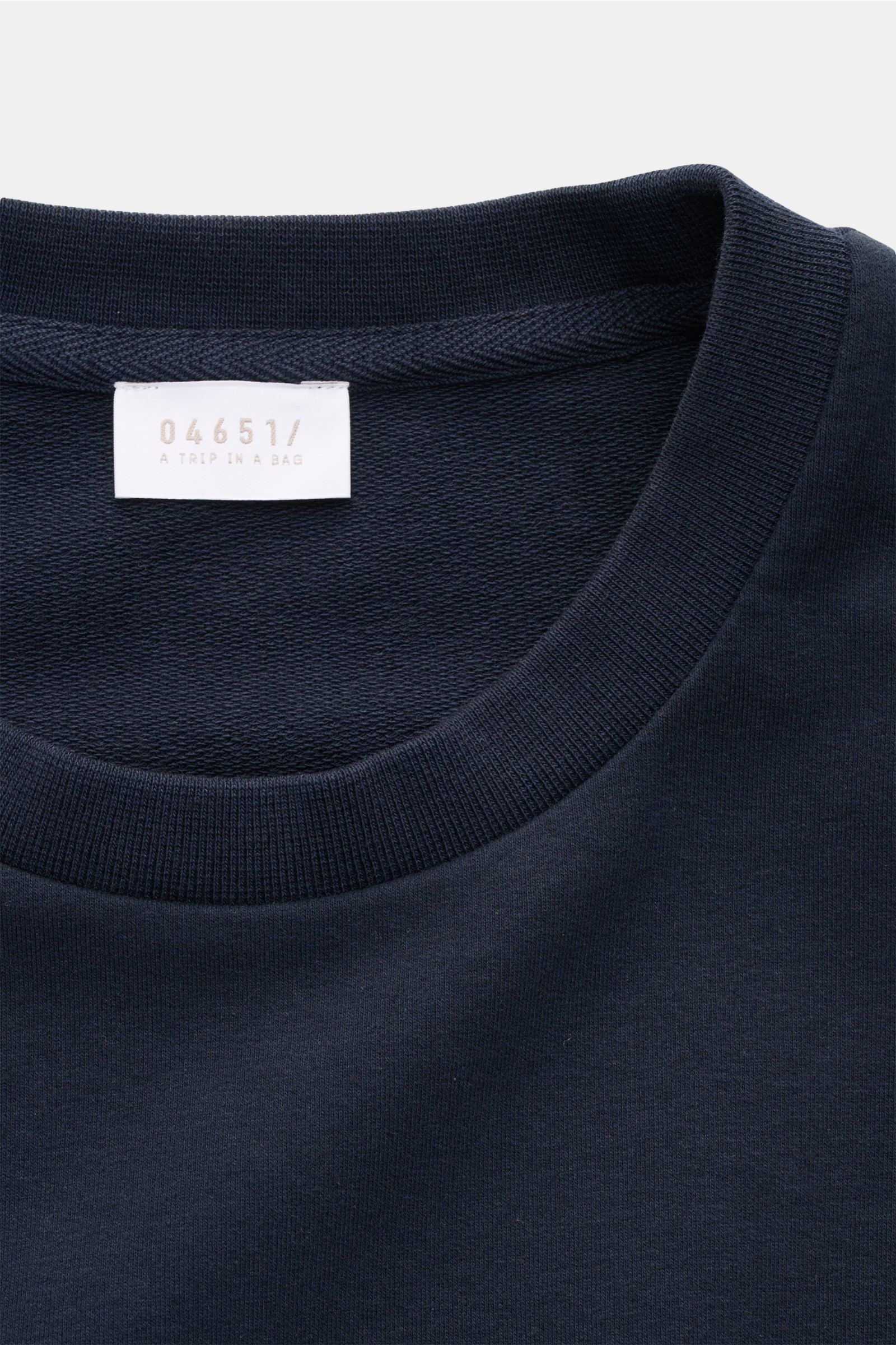 Close-up front view of 04651/ A trip in a bag Crew neck T-shirt 'If Tee' navy, showing elasticated cotton jersey and label.

The uncomplicated cotton T-shirt 'IF Tee' by 04651/ A TRIP IN A BAG is a core basic for the new season that give us a taste of 