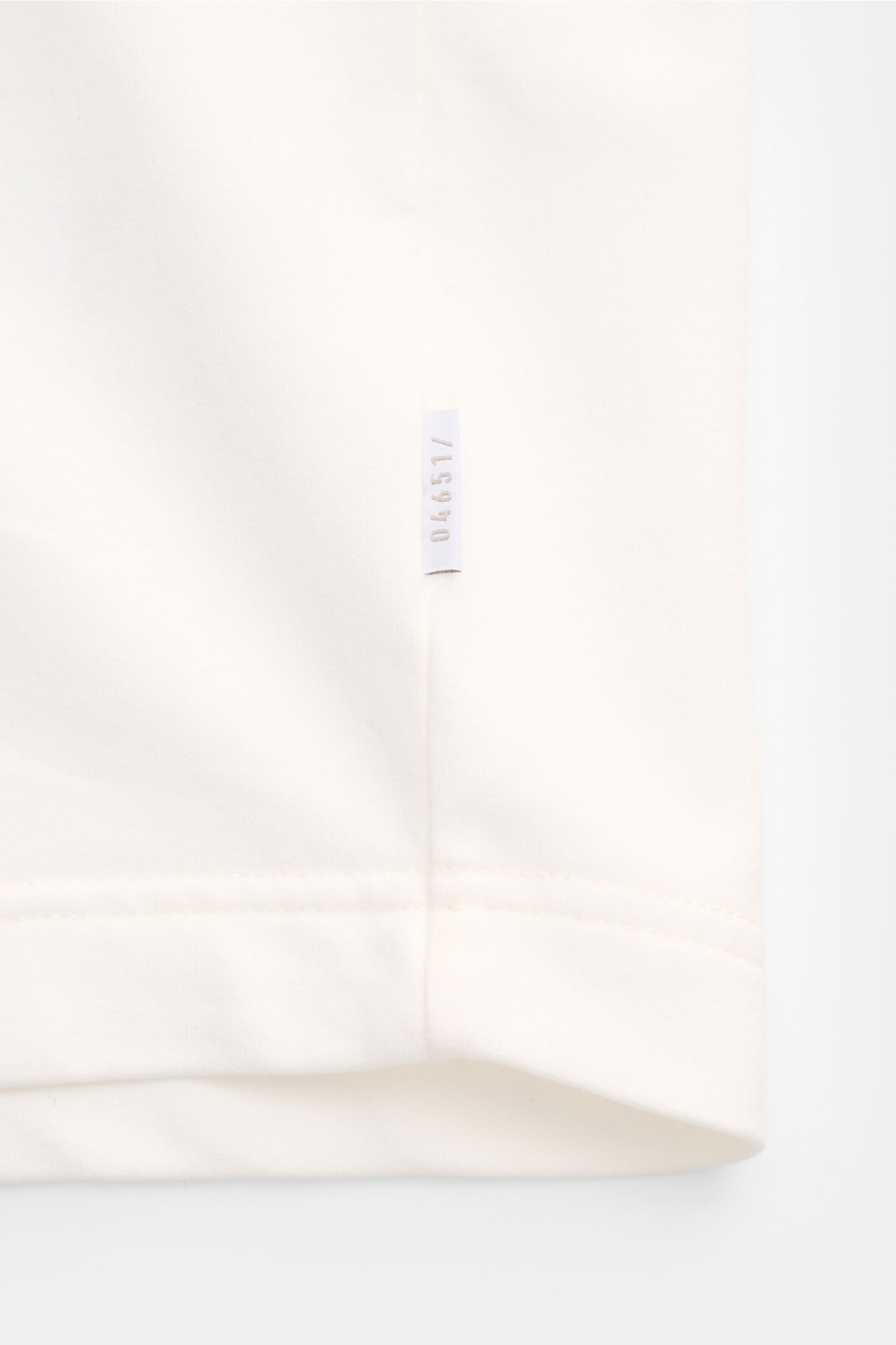 Close-up side seam view of 04651/ A trip in a bag Crew neck T-shirt 'If Tee' cream showing woven label on soft, heavy elasticated cotton fabric.

The uncomplicated cotton T-shirt 'IF Tee' by 04651/ A TRIP IN A BAG is a core basic for the new season tha