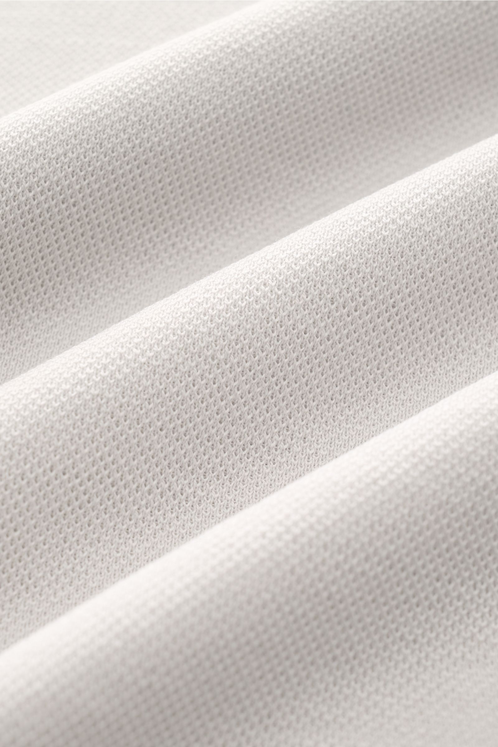 Nahaufnahme des hellgrauen 04651/ A trip in a bag Piqué-T-Shirt 'TP' Gewebes mit kernigem Griff aus reiner Baumwolle, Detail von Piqué-Struktur.
