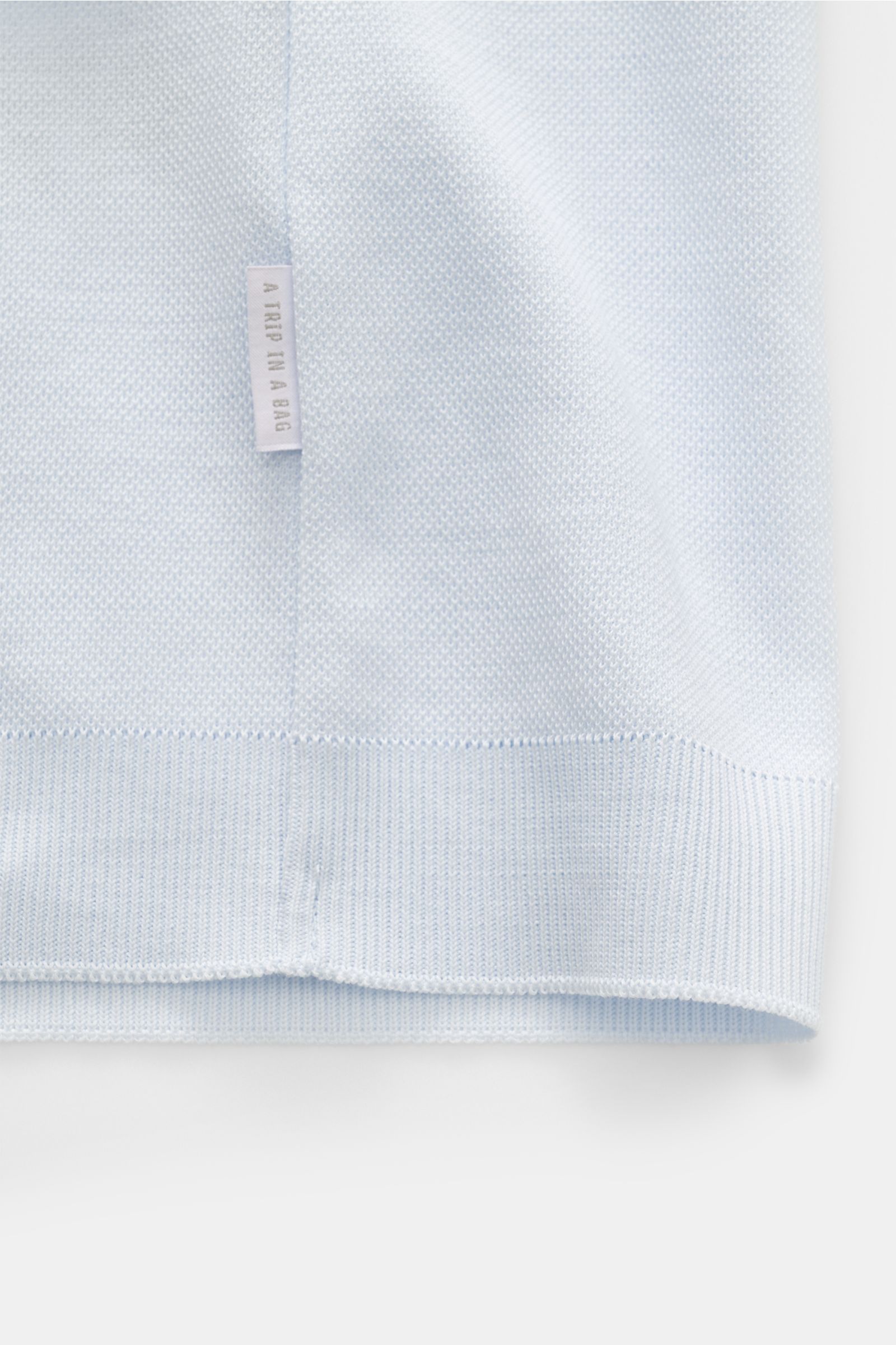 04651/ A trip in a bag Piqué-T-Shirt 'TP' pastellblau Nahaufnahme der unteren Kante mit Weblabel, Slim Fit, Rundhalsausschnitt, Rippbündchen, reine Baumwolle, kerniger Griff.
