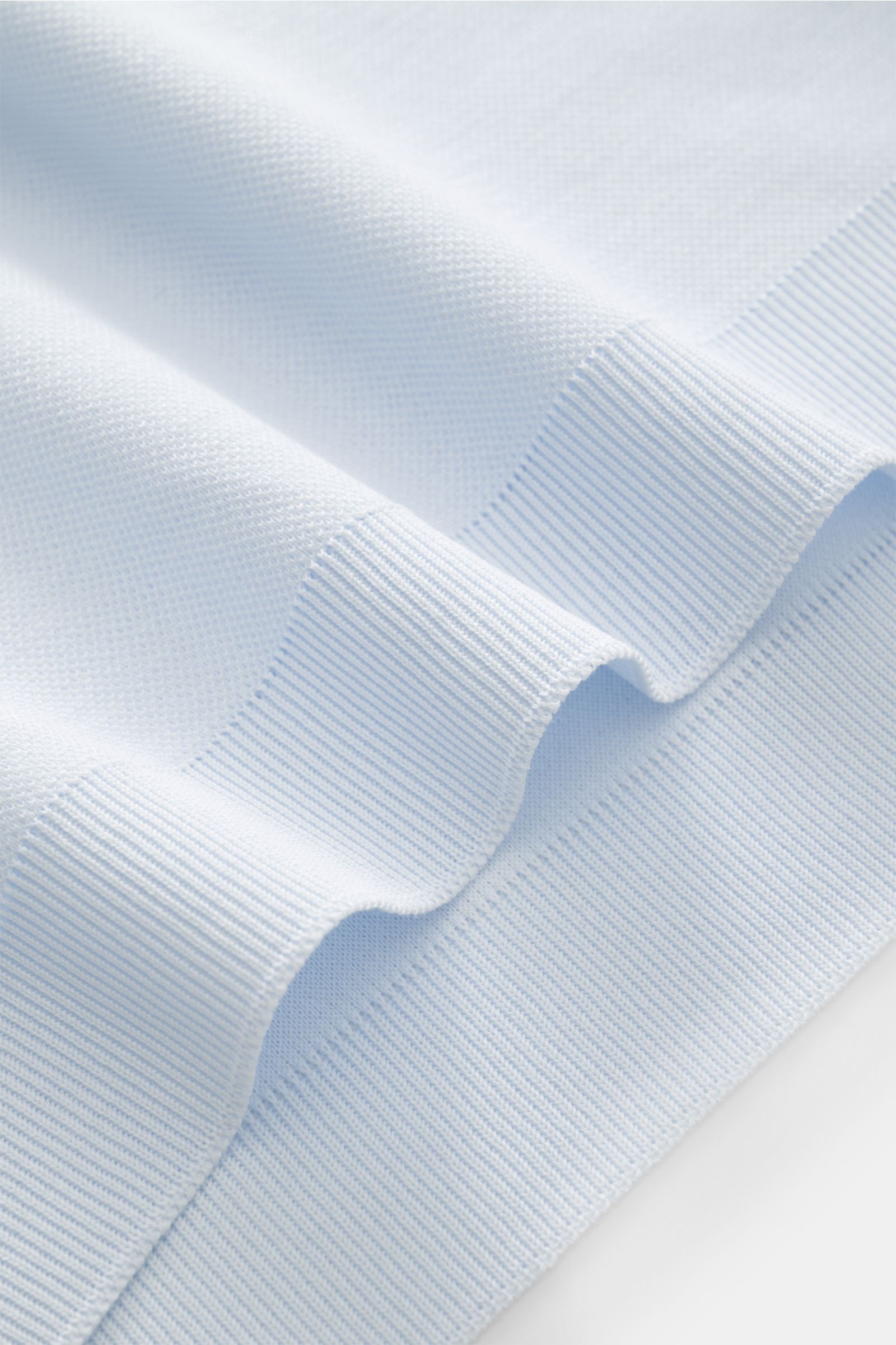 Detailaufnahme des hellblauen Piqué-Stoffs und der Rippbündchen aus der Nahaufnahme, 04651/ A trip in a bag Piqué-T-Shirt 'TP' pastellblau, Slim Fit, Rundhalsausschnitt, reine Baumwolle mit kernigem Griff, Weblabel in Seitennaht.