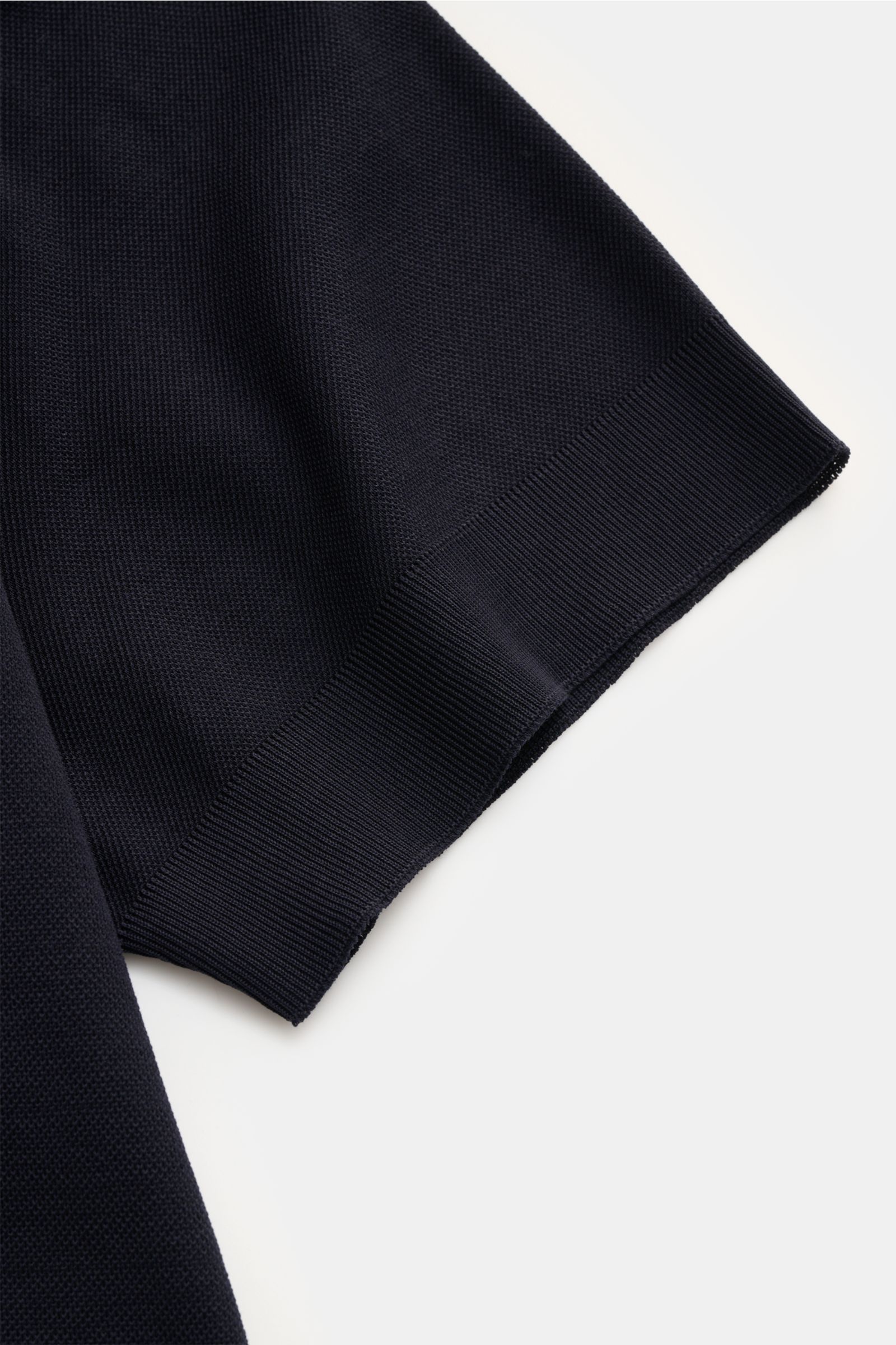 Close-up of the sleeve hem of the 04651/ A trip in a bag Piqué-T-Shirt 'TP' navy, showing the textured piqué cotton fabric and ribbed cuff from a side angle.

Summer Essential: Das Piqué-T-Shirt von 04651/ A TRIP IN A BAG überzeugt an warmen Tagen als 