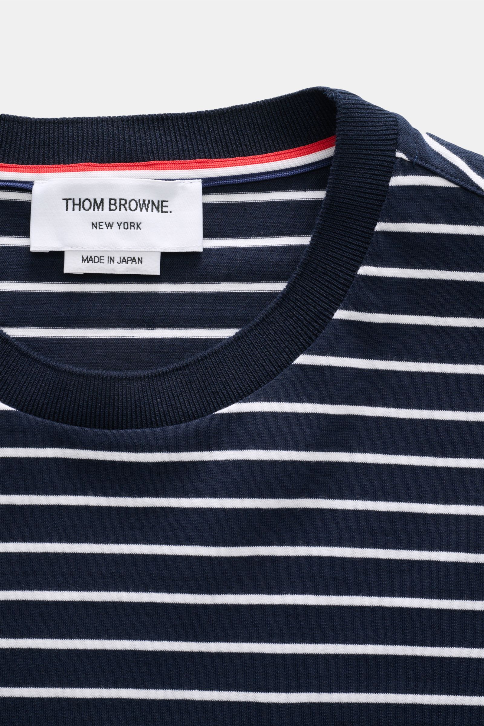 Close-up front view of the Thom Browne Rundhals-T-Shirt navy/weiß gestreift showing navy and white stripes and ribbed collar.

Zeitlos maritim: Das T-Shirt von THOM BROWNE aus reiner Baumwolle verbindet entspannte Jersey-Qualität mit stilvoller Streetw