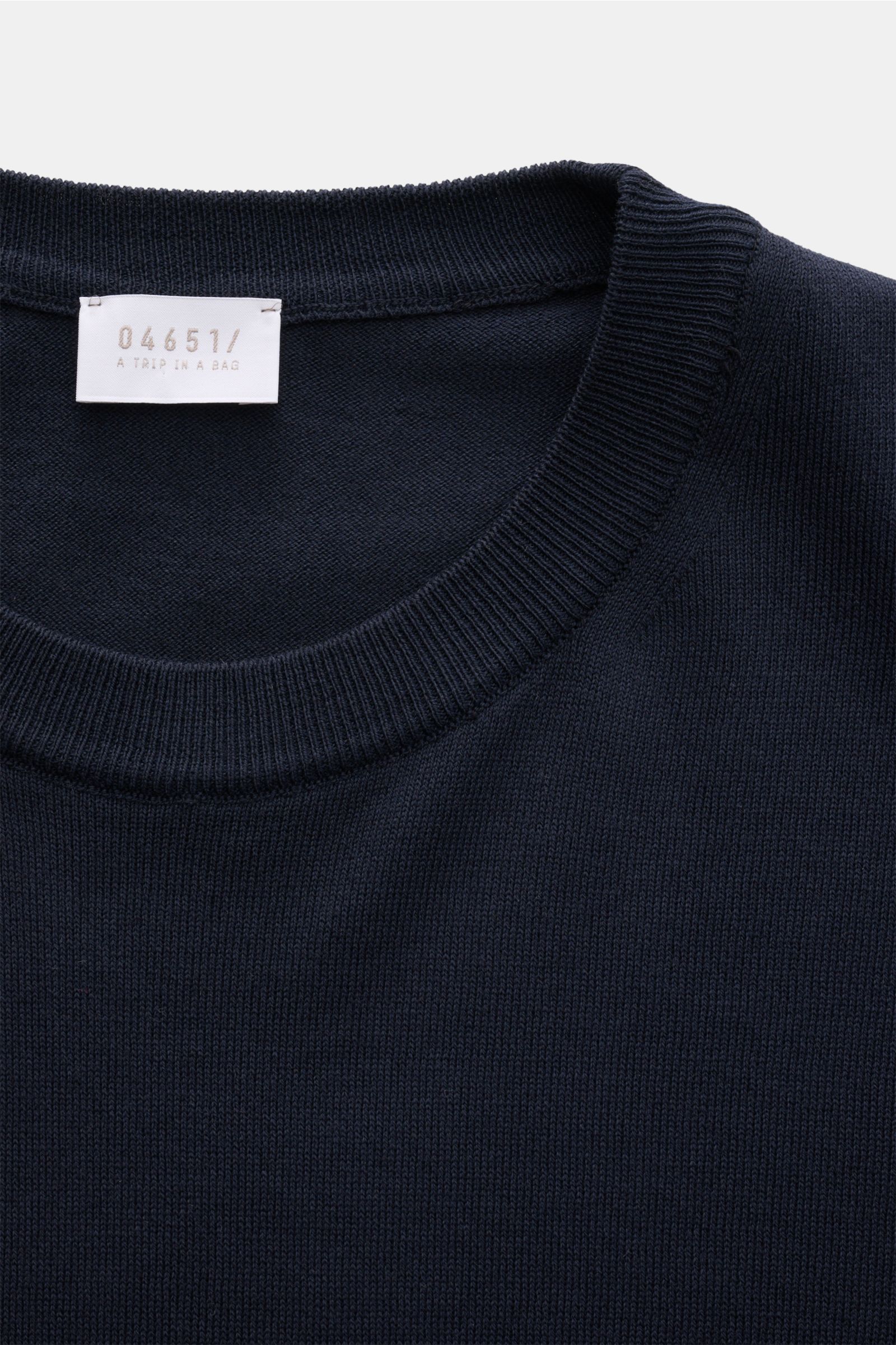 Close-up top view of navy knit short-sleeve pullover showing ribbed round neckline and fine stitch, 04651/ A trip in a bag Kurzarmpullover 'Pima Cotton' navy.

Description: Aus feiner Pima-Baumwolle gefertigt, lässt Sie der Kurzarmpullover 'Pima Cotton