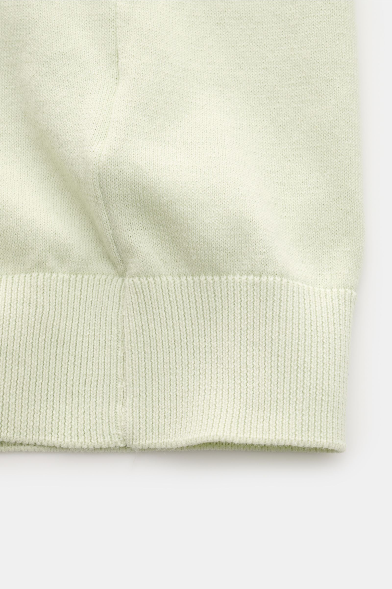 Close-up front view of the ribbed cuff and fine knit detail of the 04651/ A trip in a bag Kurzarmpullover 'Pima Cotton' pastellgrün made from pure Pima cotton with a soft touch, slim fit, round neckline, and flexible ribbed cuffs, perfect for warm weather