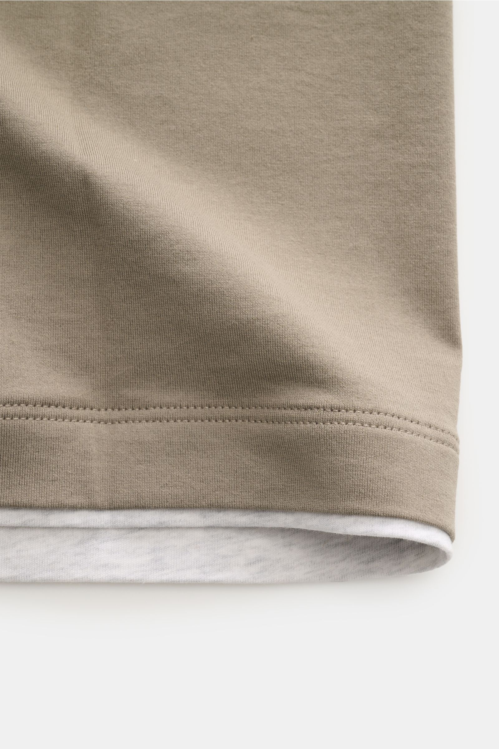 Alt tag (125 characters max):
Close-up from the side of the hem of Brunello Cucinelli Rundhals-T-Shirt taupe/grau meliert with double-stitched trim.

Description:
BRUNELLO CUCINELLI liefert mit diesem legeren T-Shirt aus angenehmer Baumwolle ein unverz