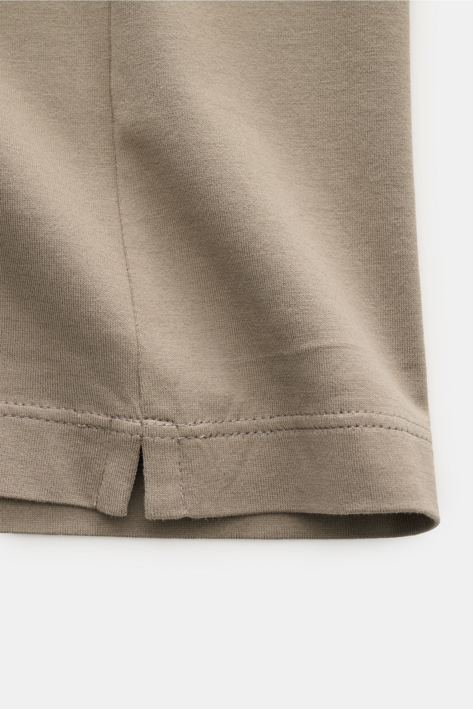 Close-up of the hem with short side slits of the taupe Brunello Cucinelli Rundhals-T-Shirt, showing fabric texture and stitching from a side angle.

Description: Luxuriöse Materialqualität und feinste Verarbeitung verleihen dem Rundhals-T-Shirt aus rei