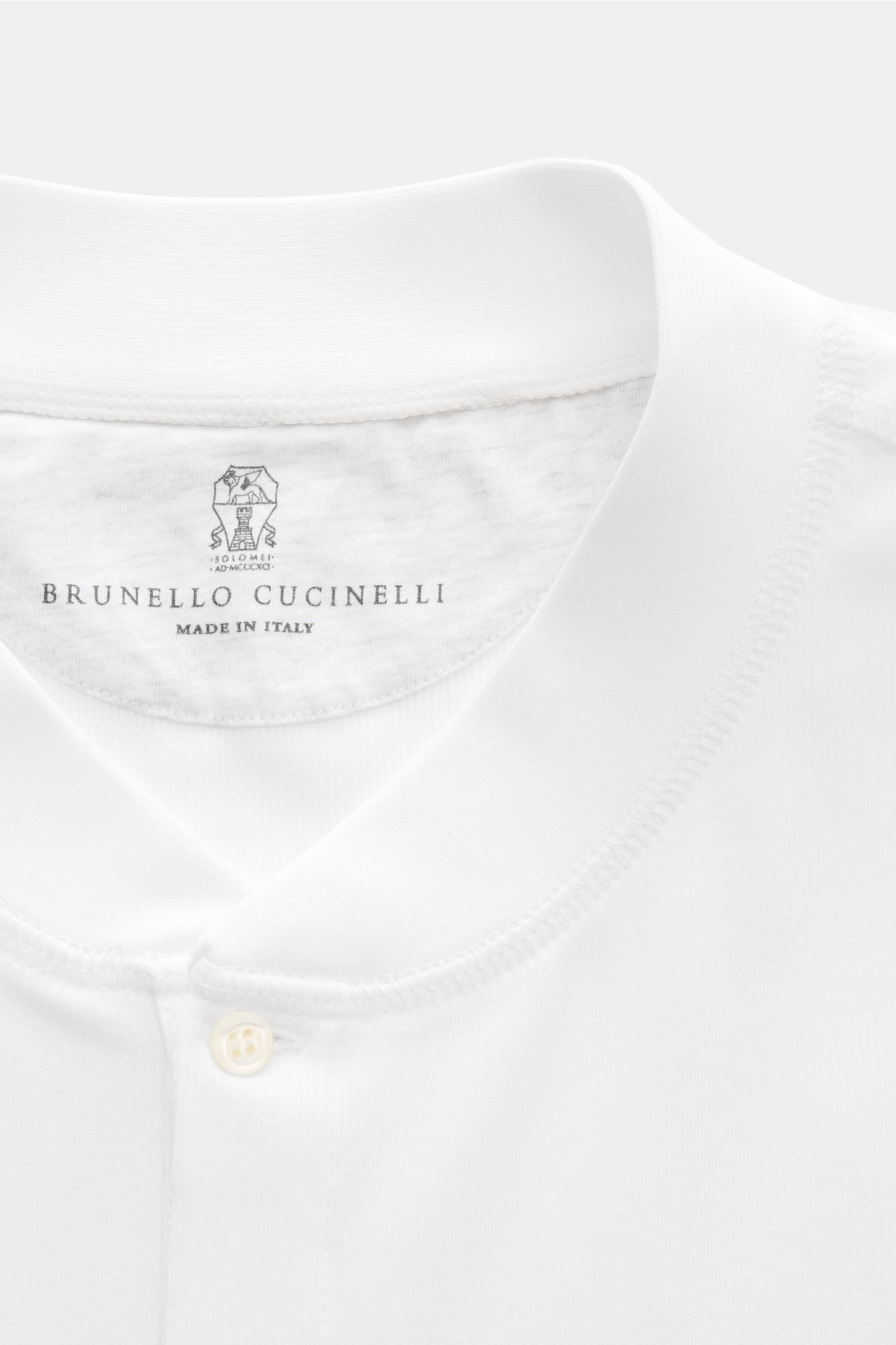 Close-up front view of the Brunello Cucinelli Henley-Shirt weiß showing the collar, three-button placket, and tonal overlock seams. Highlight in der Frühling- und Sommersaison: Das luxuriöse Henley-Shirt von BRUNELLO CUCINELLI überzeugt mit außergewöhnlic