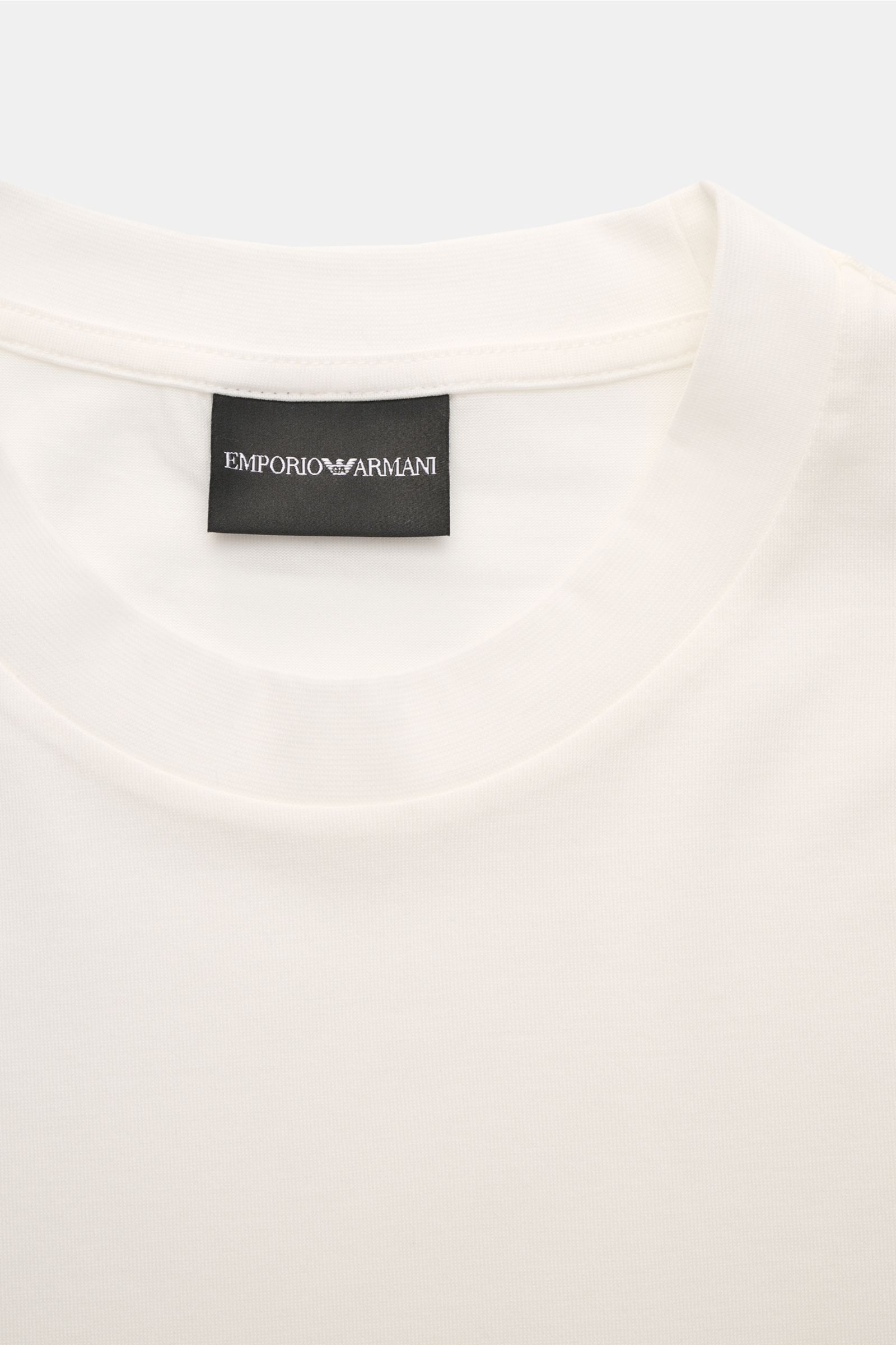 Emporio Armani Rundhals-T-Shirt offwhite in Nahaufnahme von oben, Jersey aus Lyocell-Baumwolle, glatter Griff, Rundhals, Logo-Patch am Saum.