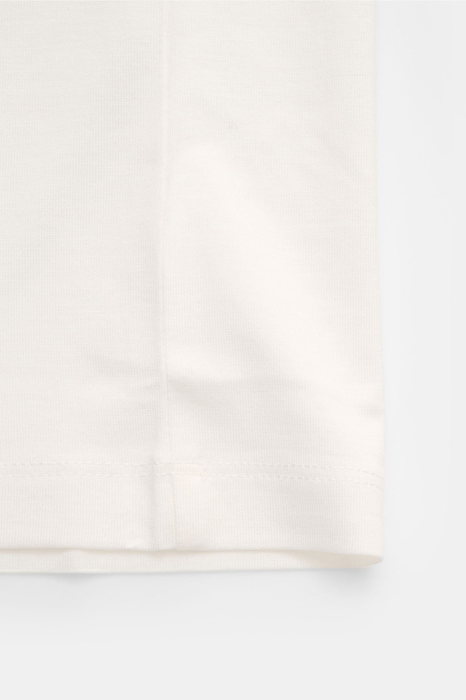 Emporio Armani Rundhals-T-Shirt offwhite, Detailaufnahme vom Saum, Jersey aus Lyocell-Baumwolle, glatter Griff, Regular Fit, Logo-Patch am Saum.