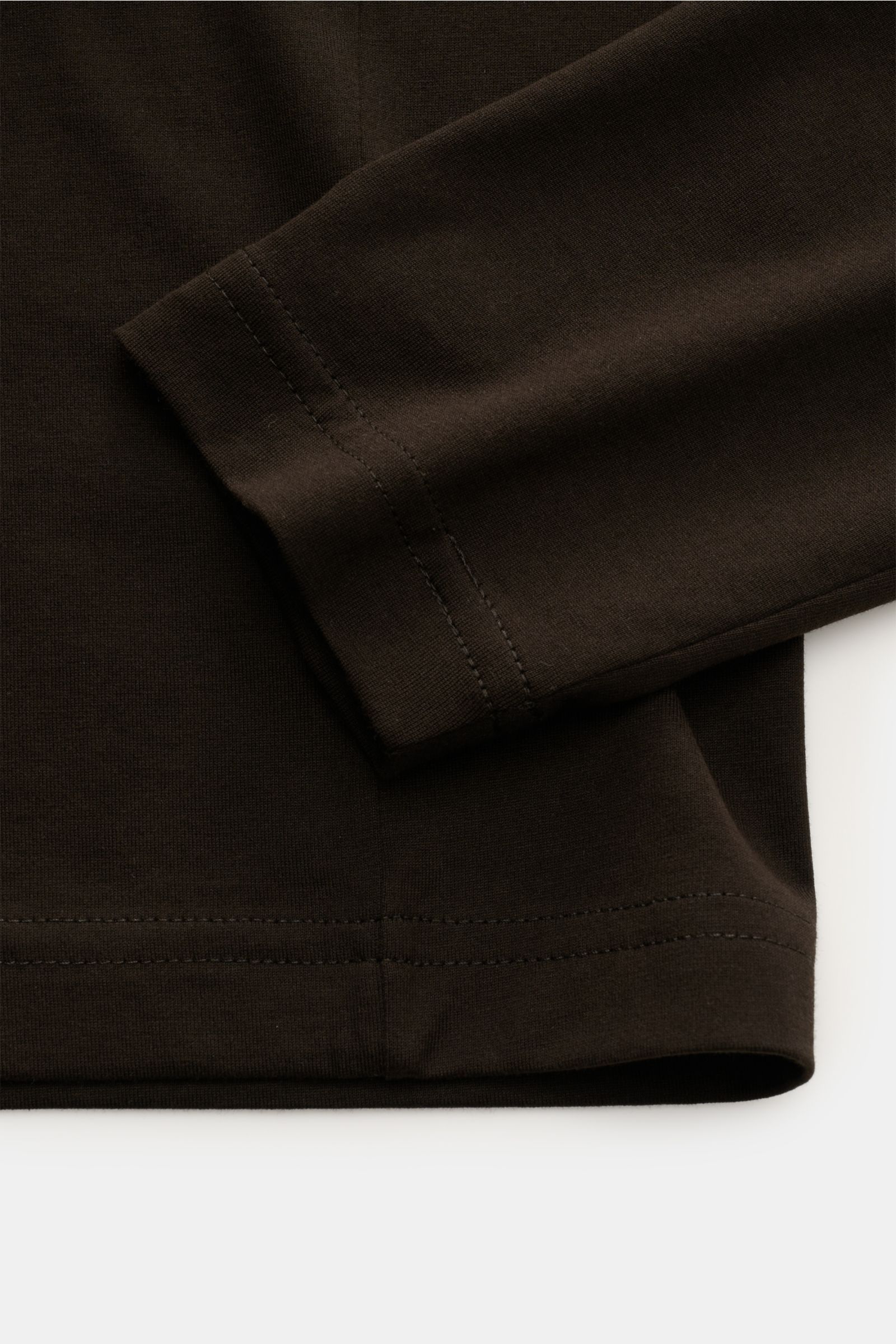 Close-up of the sleeve and hem of Stefan Brandt Crew neck long sleeve 'Enno' dark brown, photographed from above. With the long sleeve 'Enno' in fine cotton jersey, STEFAN BRANDT presents a timeless essential – well-made, durable and perfect for a styl