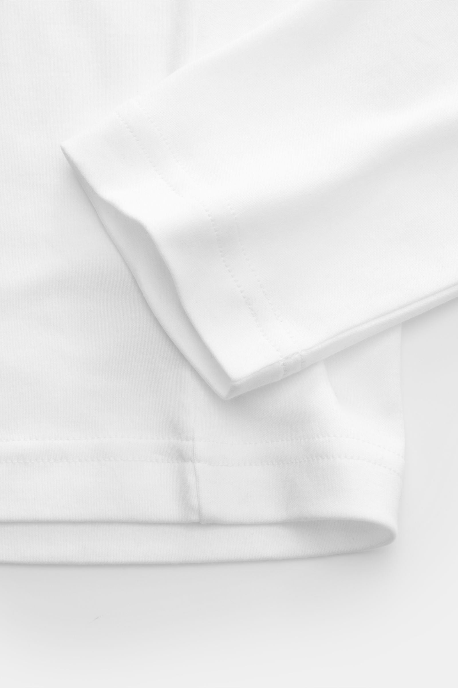 Weißes Stefan Brandt Rundhals-Longsleeve 'Sea Island Eli' aus weichem Jersey, Slim Fit, Rundhalsausschnitt, Detailaufnahme Ärmel und Saum.
