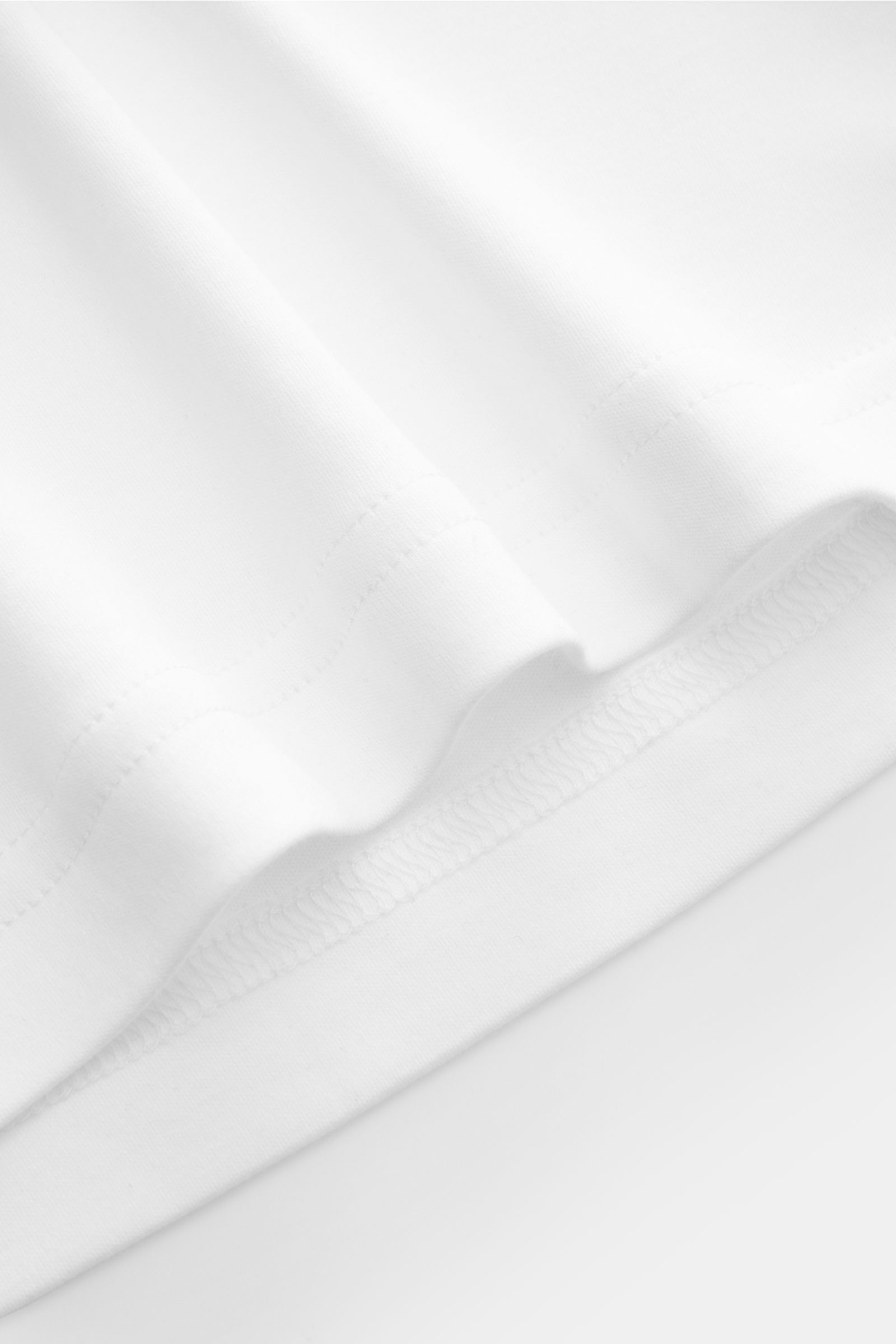Nahaufnahme des weißen Stefan Brandt Rundhals-Longsleeves 'Sea Island Eli' aus weichem, feinem Sea-Island-Baumwoll-Jersey mit Slim Fit.