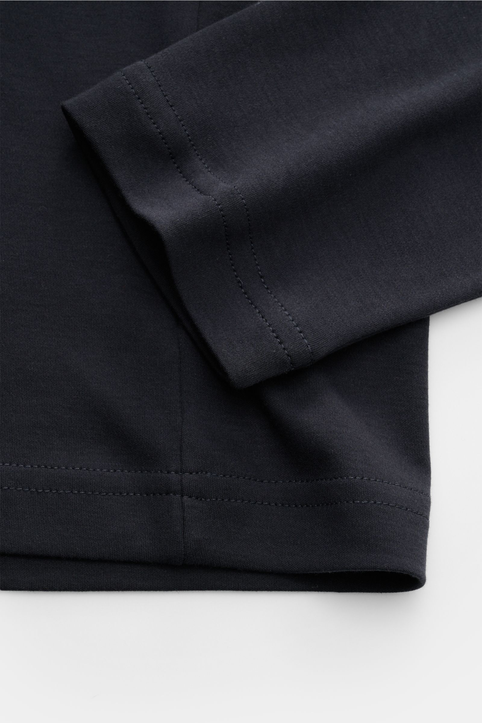 Nahaufnahme des Saums und Ärmels eines Stefan Brandt Rundhals-Longsleeve 'Sea Island Eli' dark navy aus weichem, reinem Sea-Island-Baumwoll-Jersey, Slim Fit mit Rundhalsausschnitt.