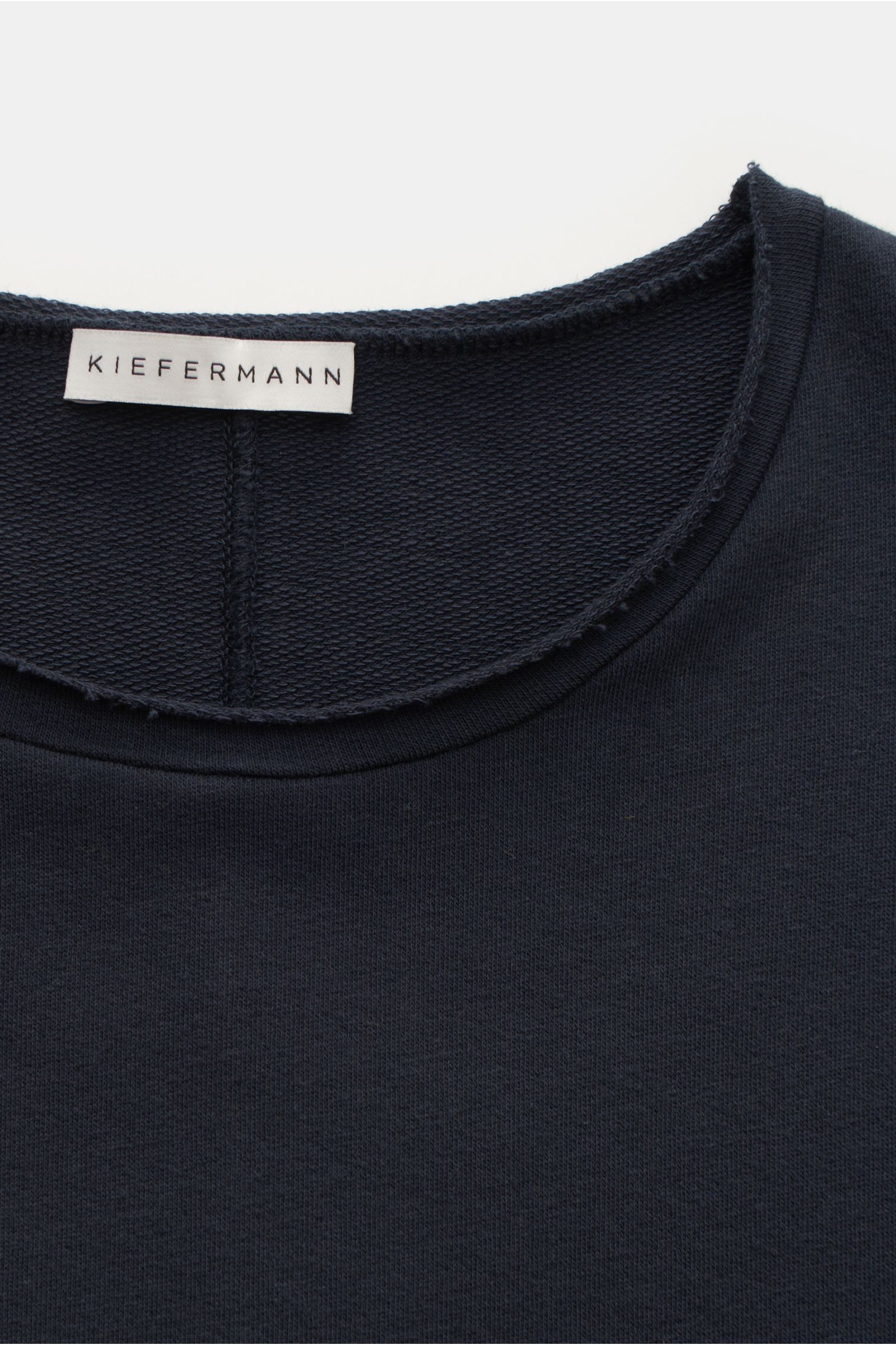 Nahaufnahme des Kiefermann Rundhals-Longsleeve 'Frankon' navy mit offenem, rolliertem Saum und rückwärtiger Teilungsnaht.