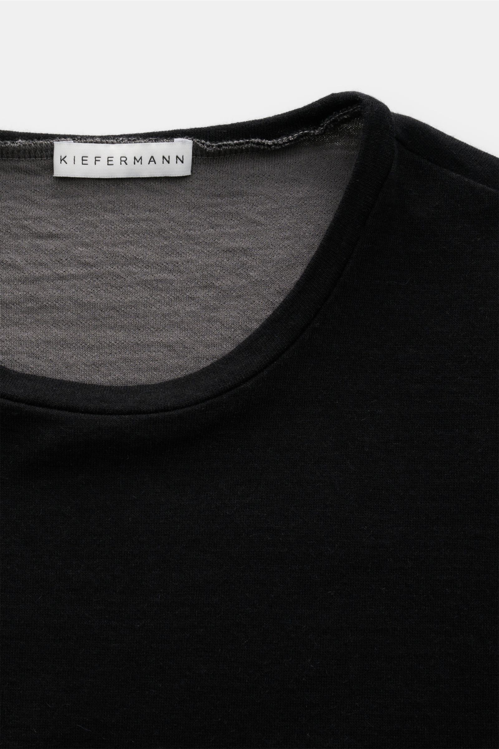 Nahaufnahme des schwarzen Kiefermann Longsleeve 'Jeldrik' mit Rundhalsausschnitt, offen verarbeiteten Saumkanten, Regular Fit, Baumwolle und Cashmere.