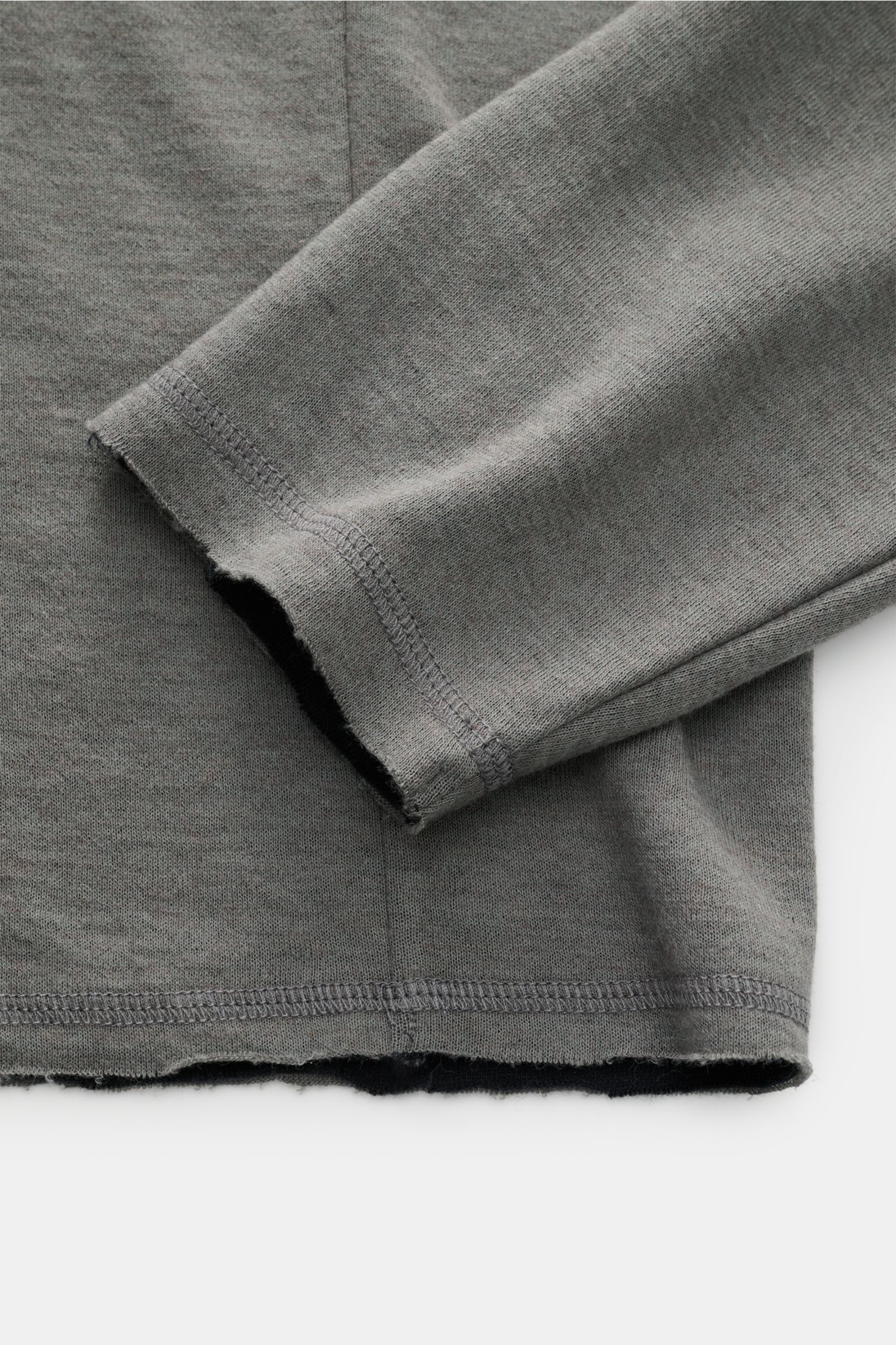 Close-up view of the sleeve and hem of the Kiefermann Longsleeve 'Jeldrik' grau, showing its soft grey fabric and open edges.

Description: Lässiges Basic: Das Longsleeve 'Jeldrik' von KIEFERMANN überzeugt mit seinem komfortablen Material aus doppellag