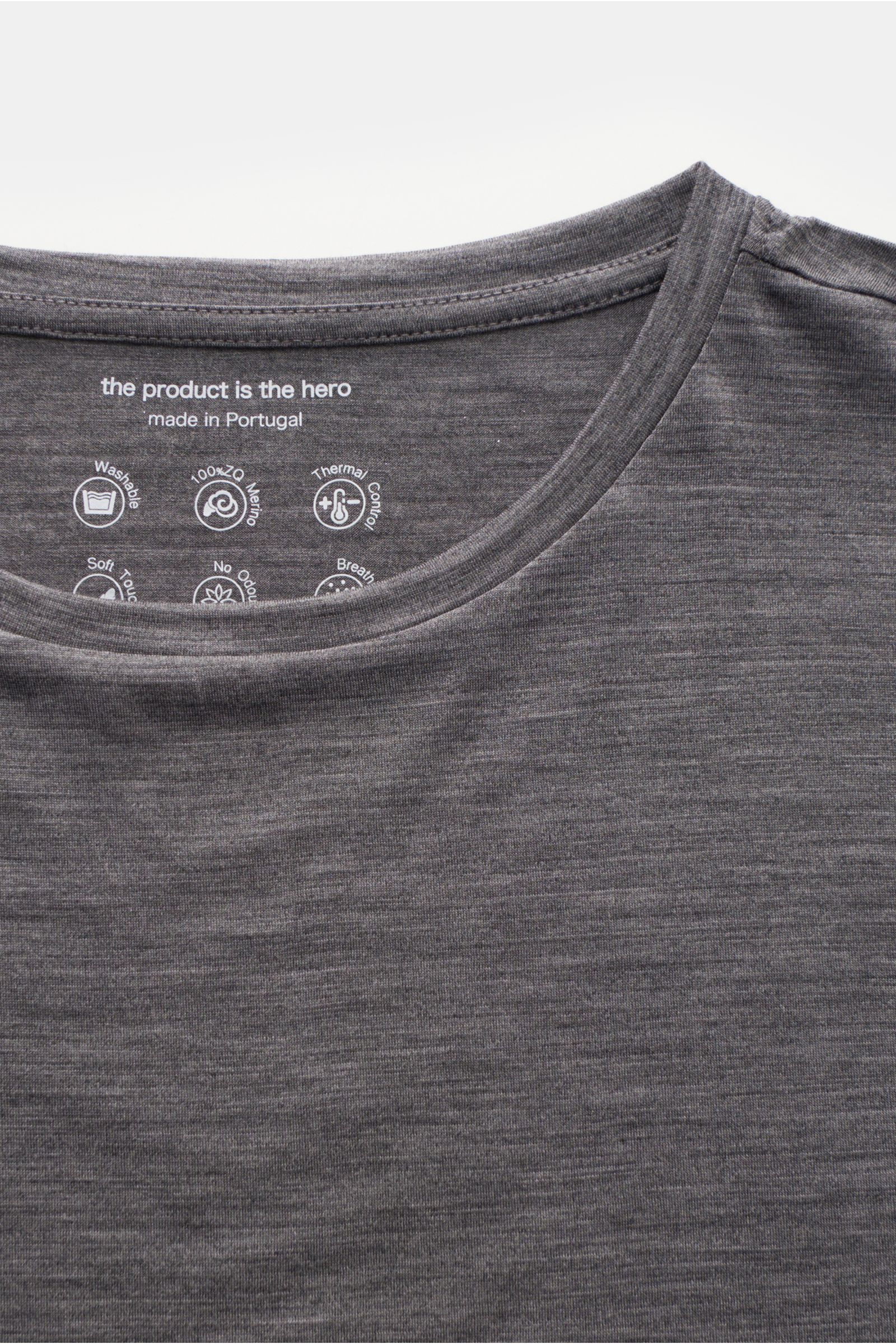 The Product is the Hero Merino Longsleeve dunkelgrau meliert in Nahaufnahme von oben, leichter Slim Fit mit Rundhalsausschnitt, aus reiner Merinowolle, weich, atmungsaktiv und wärmeregulierend.