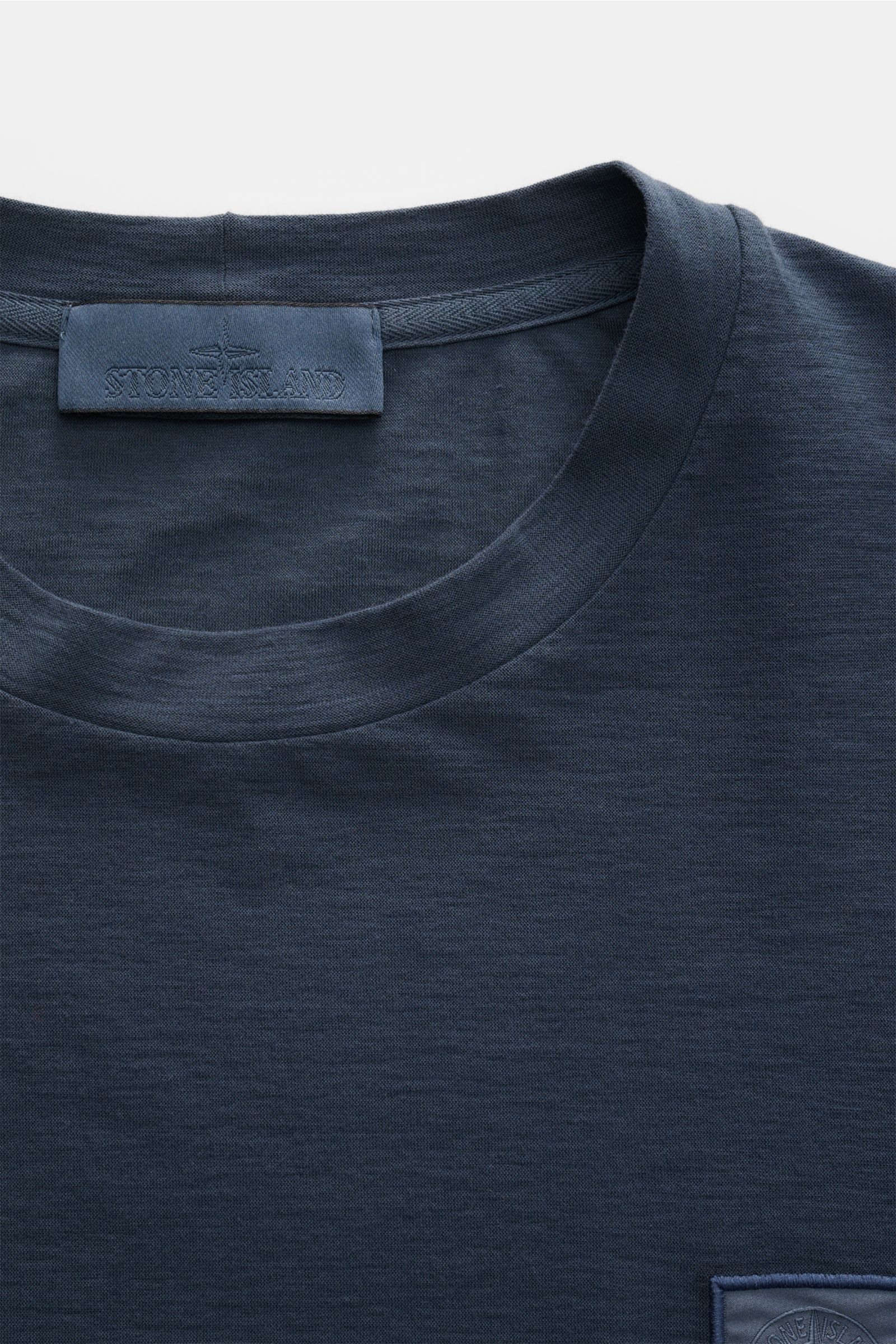 Stone Island Longsleeve 'Ghost Piece' graublau, Slim Fit Jersey aus Baumwolle, Rundhalsausschnitt, tonales Weblabel, Detailansicht von oben.