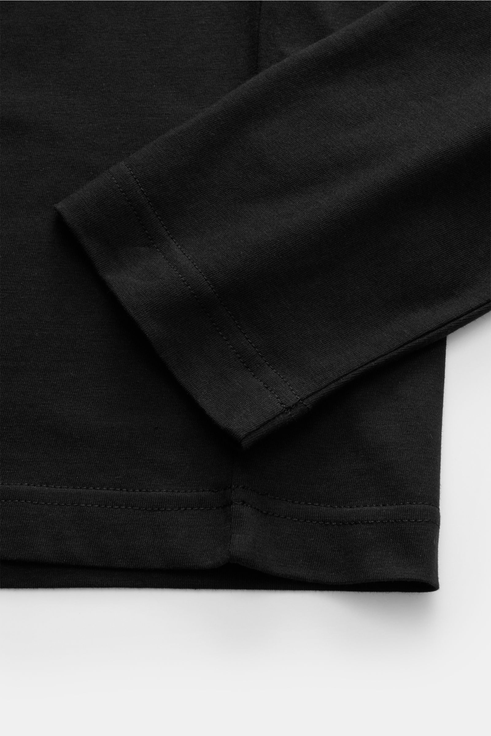 Close-up side view of Belstaff Rundhals-Longsleeve schwarz in black cotton jersey, showing sleeve and hem stitching details.

Description: Leichter Baumwolljersey als Ausgangspunkt für alltäglichen Komfort: Das klassische Rundhals-Longsleeve vom britis