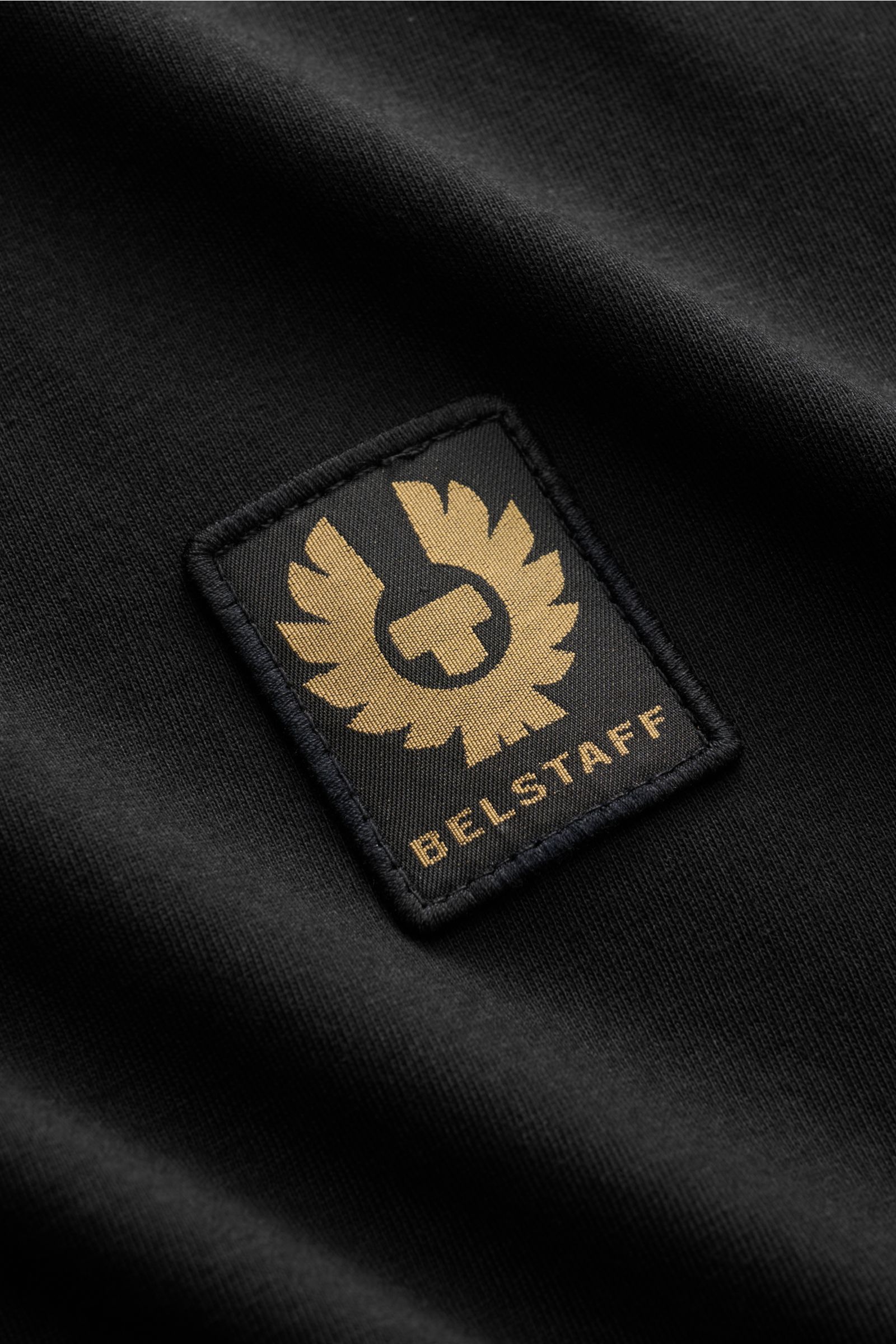 Close-up front view of Belstaff Rundhals-Longsleeve schwarz showing the black cotton jersey fabric and gold BELSTAFF weblabel on the chest.

Description: Leichter Baumwolljersey als Ausgangspunkt für alltäglichen Komfort: Das klassische Rundhals-Longsl