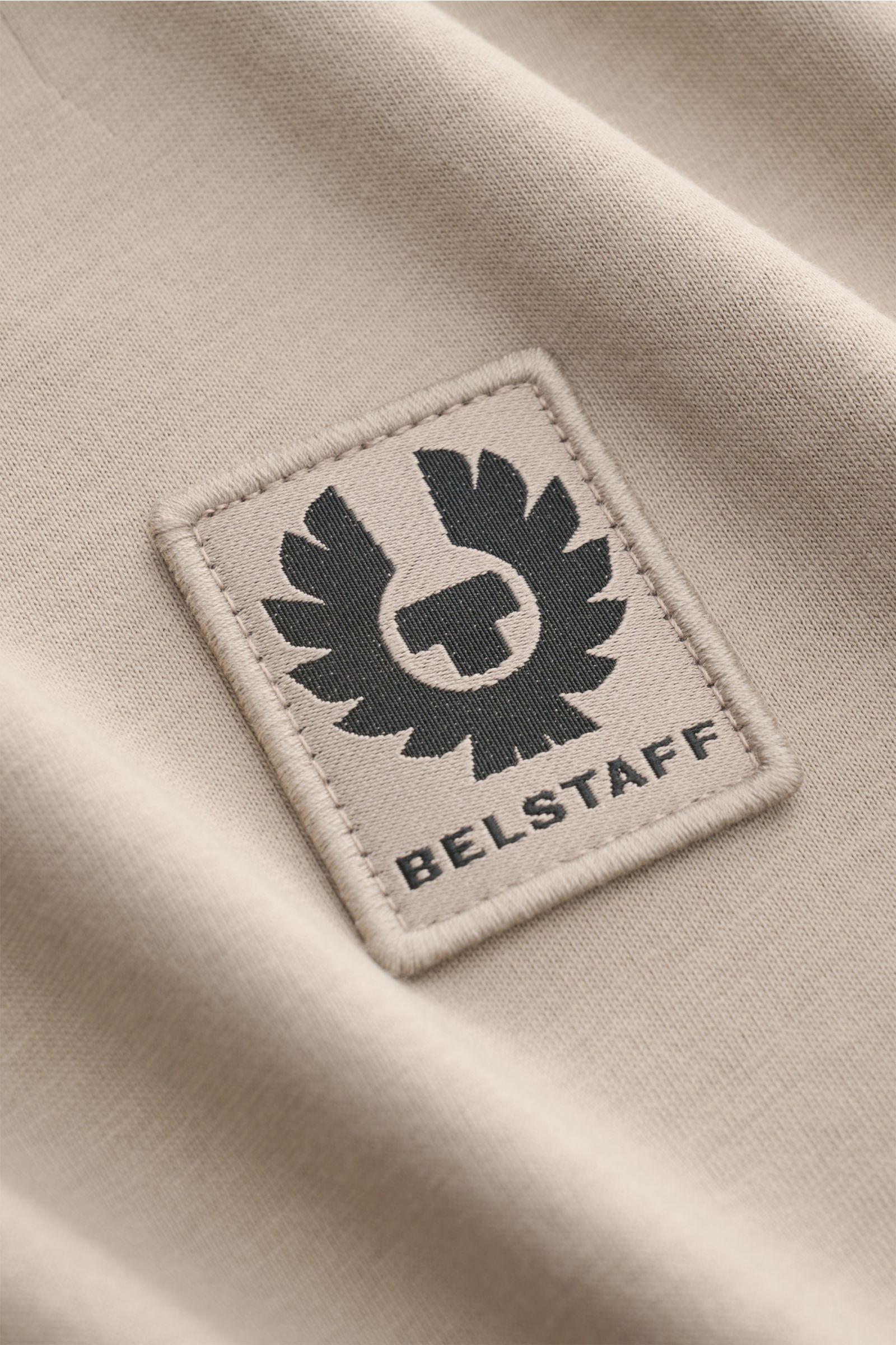 Close-up front perspective of Belstaff Crew neck long sleeve beige showing smooth lightweight cotton jersey with slim fit and woven label on chest.

Lightweight cotton jersey as a starting point for everyday comfort: This classic crew neck long sleeve 