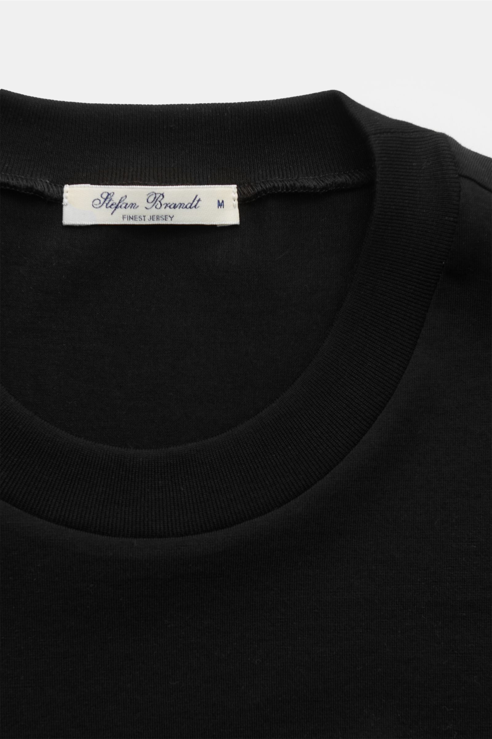 Close-up front view of Stefan Brandt Rundhals-Longsleeve 'Eli' schwarz showing the round neckline and label. Die Jersey-Essentials von STEFAN BRANDT punkten mit der exklusiven Verarbeitung hochwertiger organischer Pima-Baumwolle: farbecht, formstabil und 