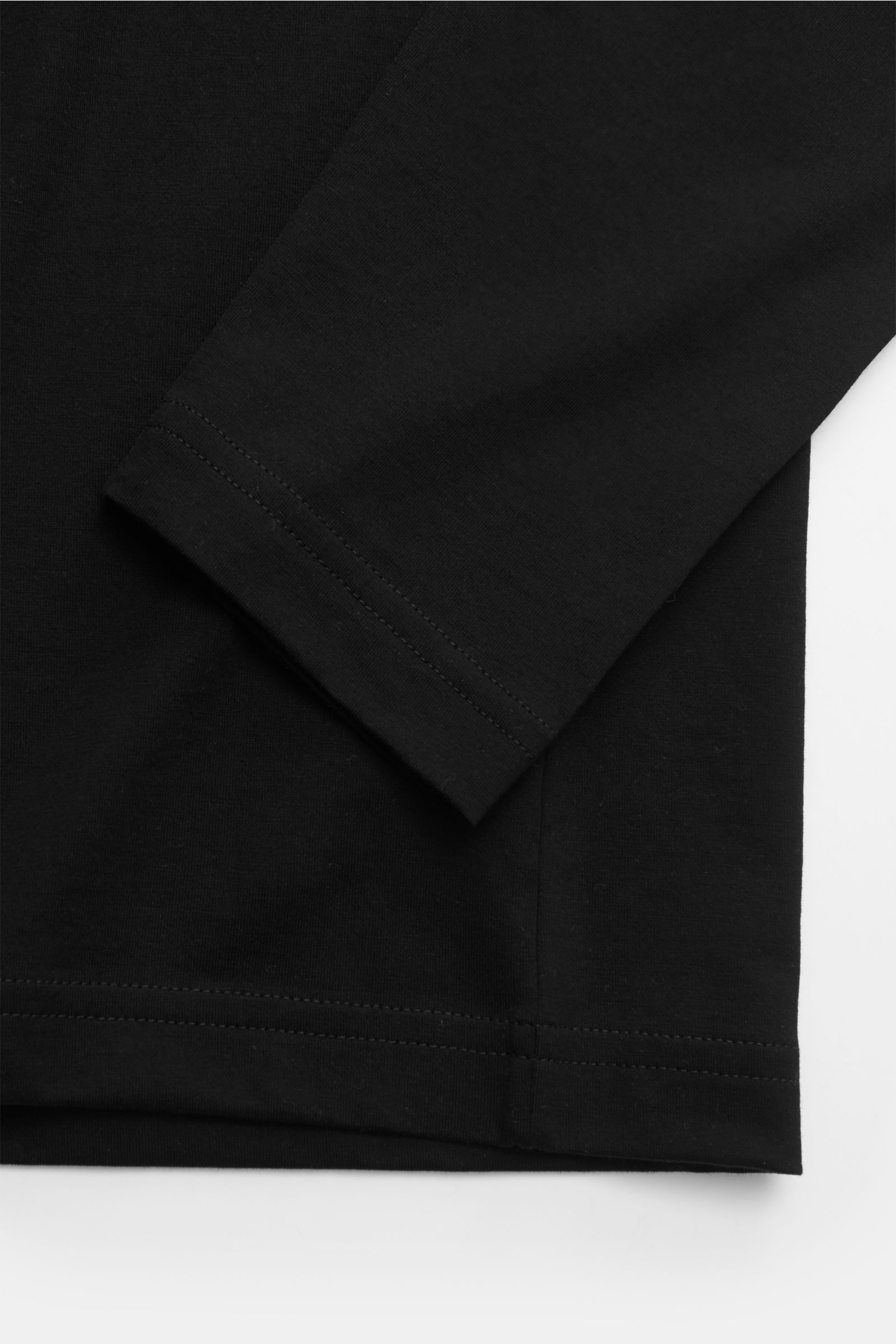 Close-up view of the sleeve and hem of the Stefan Brandt Rundhals-Longsleeve 'Eli' schwarz, made of fine organic Pima cotton jersey. Die Jersey-Essentials von STEFAN BRANDT punkten mit der exklusiven Verarbeitung hochwertiger organischer Pima-Baumwolle: f