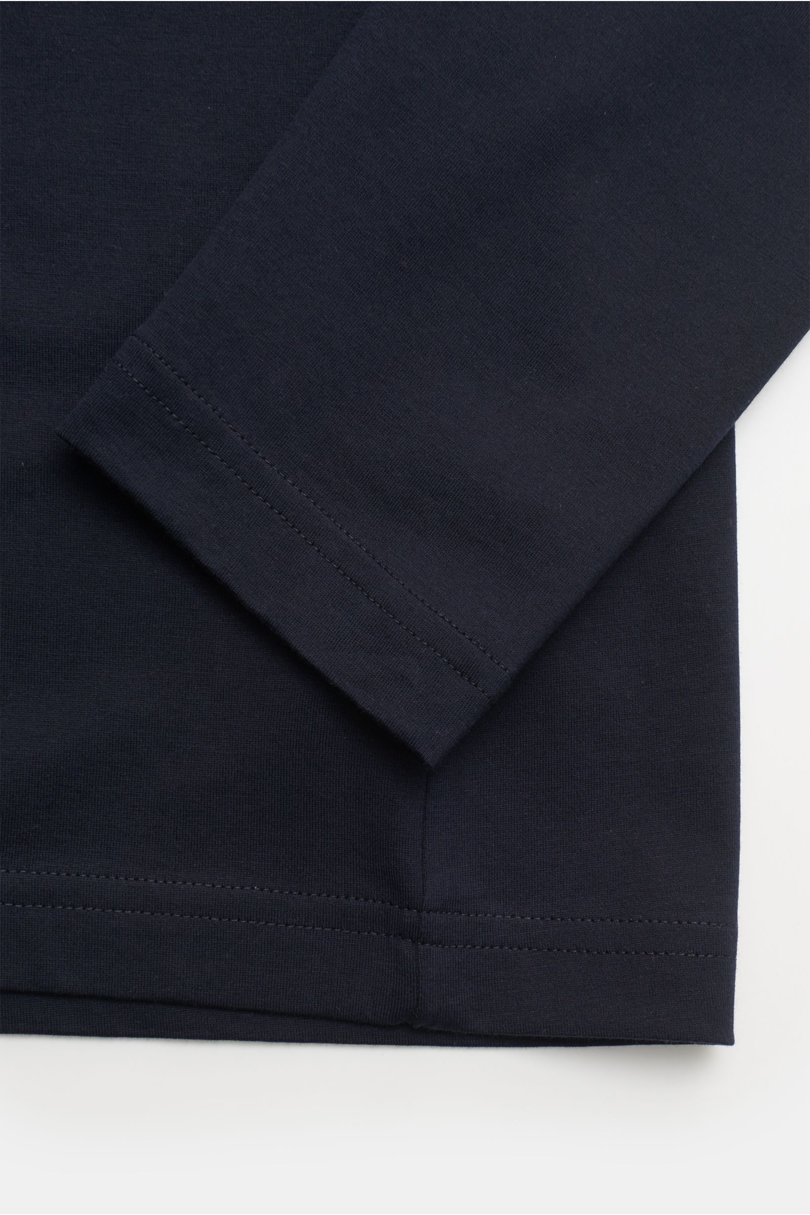 Nahaufnahme des Ärmels und Saums des Stefan Brandt Rundhals-Longsleeve 'Eli' dark navy aus feiner Jersey-Qualität. Die Perspektive zeigt den Ärmel diagonal von oben, Details der hochwertigen, biologischen Pima-Baumwolle sind sichtbar. Das Slim Fit Longsle