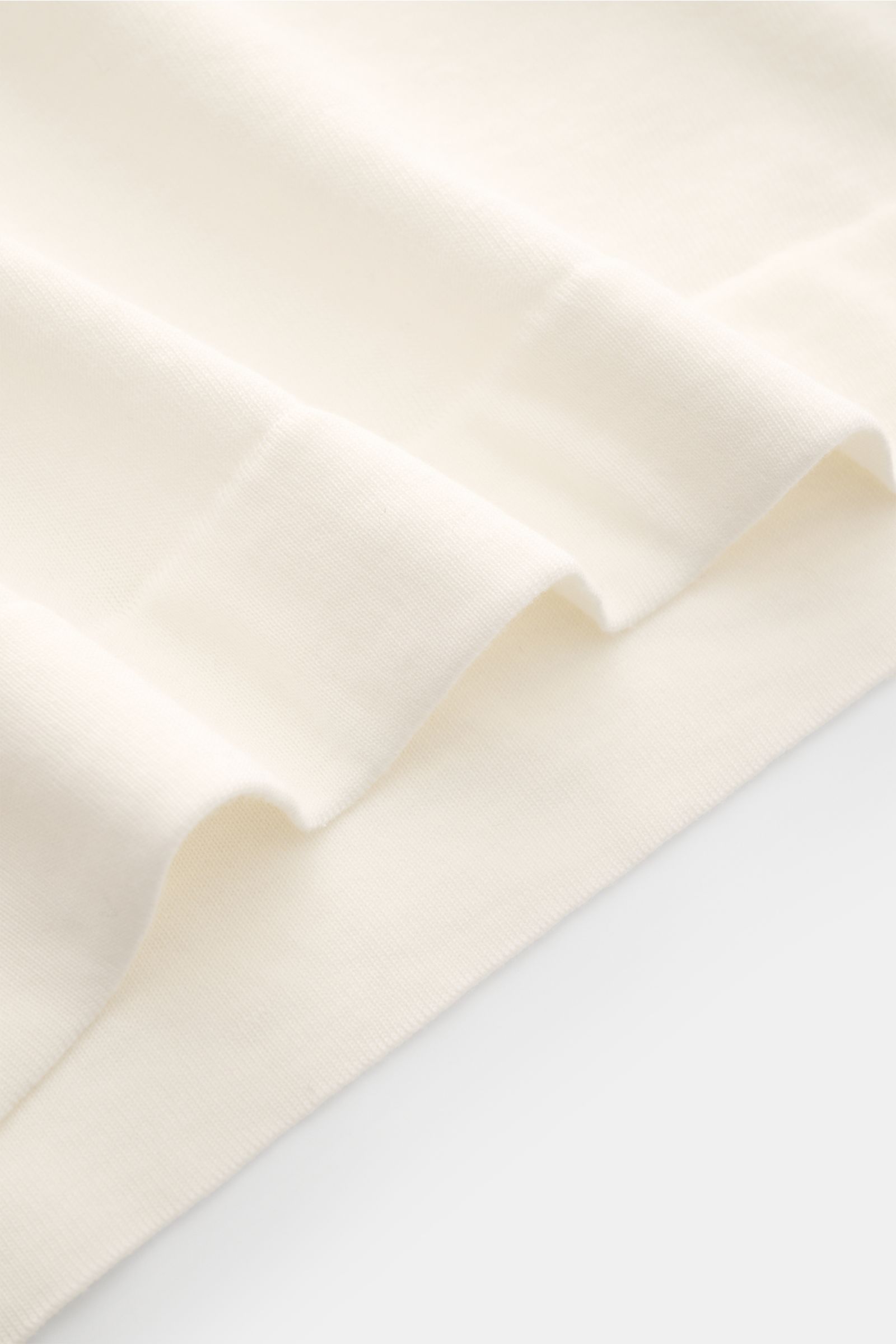 Nahaufnahme des weißen Drumohr Feinstrickpullovers, Detailfoto der flachen Bündchen aus ultra feinem Baumwollgarn, Slim Fit, Rundhalsausschnitt, sehr leichte Qualität.