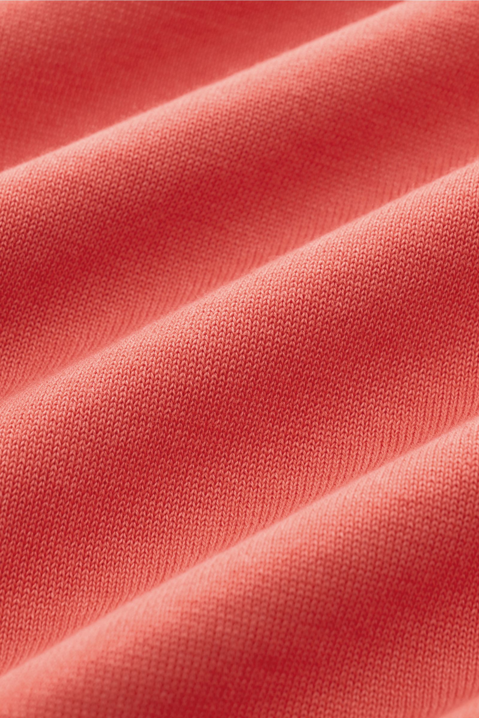 Drumohr Feinstrickpullover hellrot aus feinstem Baumwollgarn, weicher Griff, leichte Qualität, Slim Fit, flache Bündchen, Nahaufnahme der Strickstruktur.